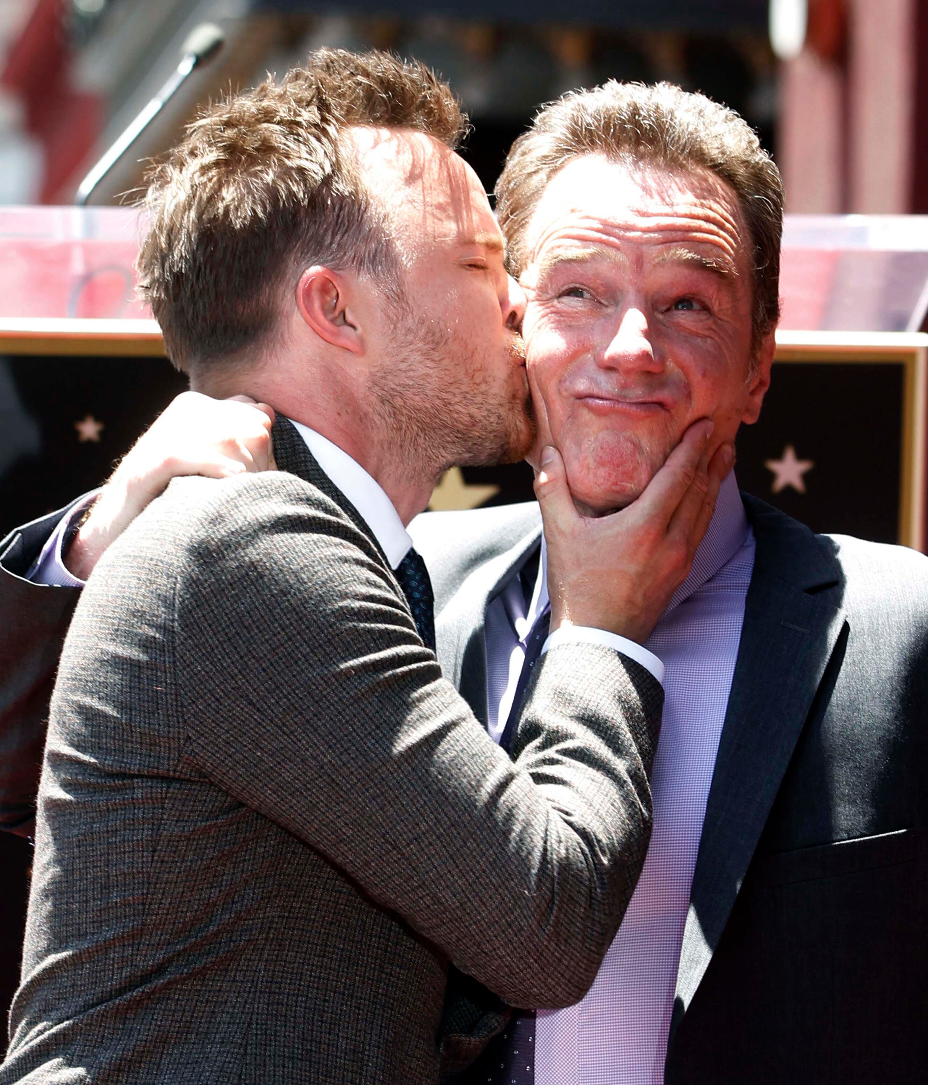 Actor Bryan Cranston (R) reacts to a kiss by his "Breaking Bad" co-star Aaron Paul during ceremonies to unveil his star on the Hollywood Walk of Fame in Hollywood July 16, 2013. Cranston stars in the AMC drama series "Breaking Bad."