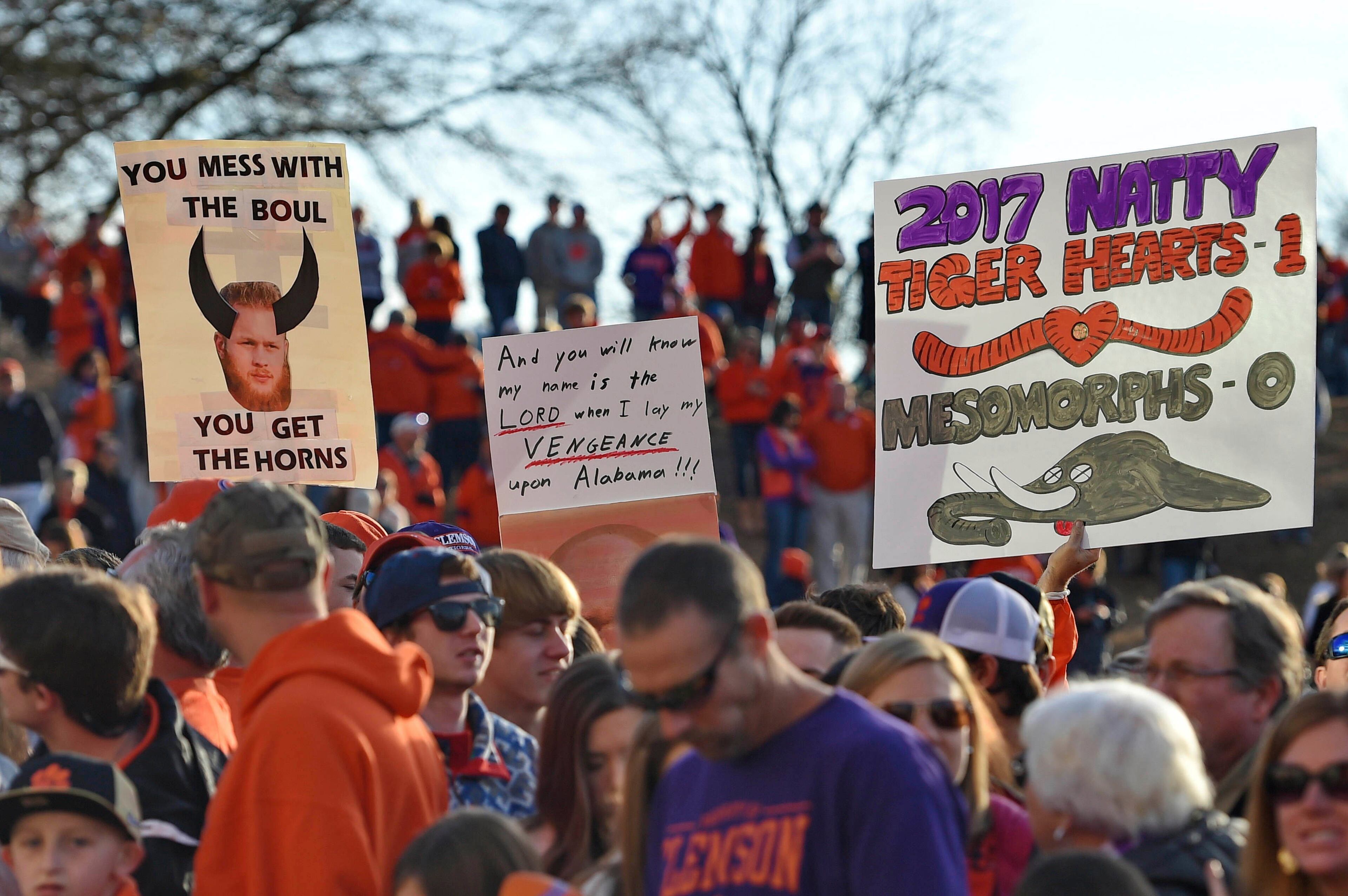 Clemson fans hold up signs as the Clemson Tigers return Tuesday, Jan. 10, 2017, in Clemson, S.C., the day after Clemson defeated Alabama 35-31 in the NCAA College Football Playoff championship game in Tampa, Fla. (AP Photo/Richard Shiro)
