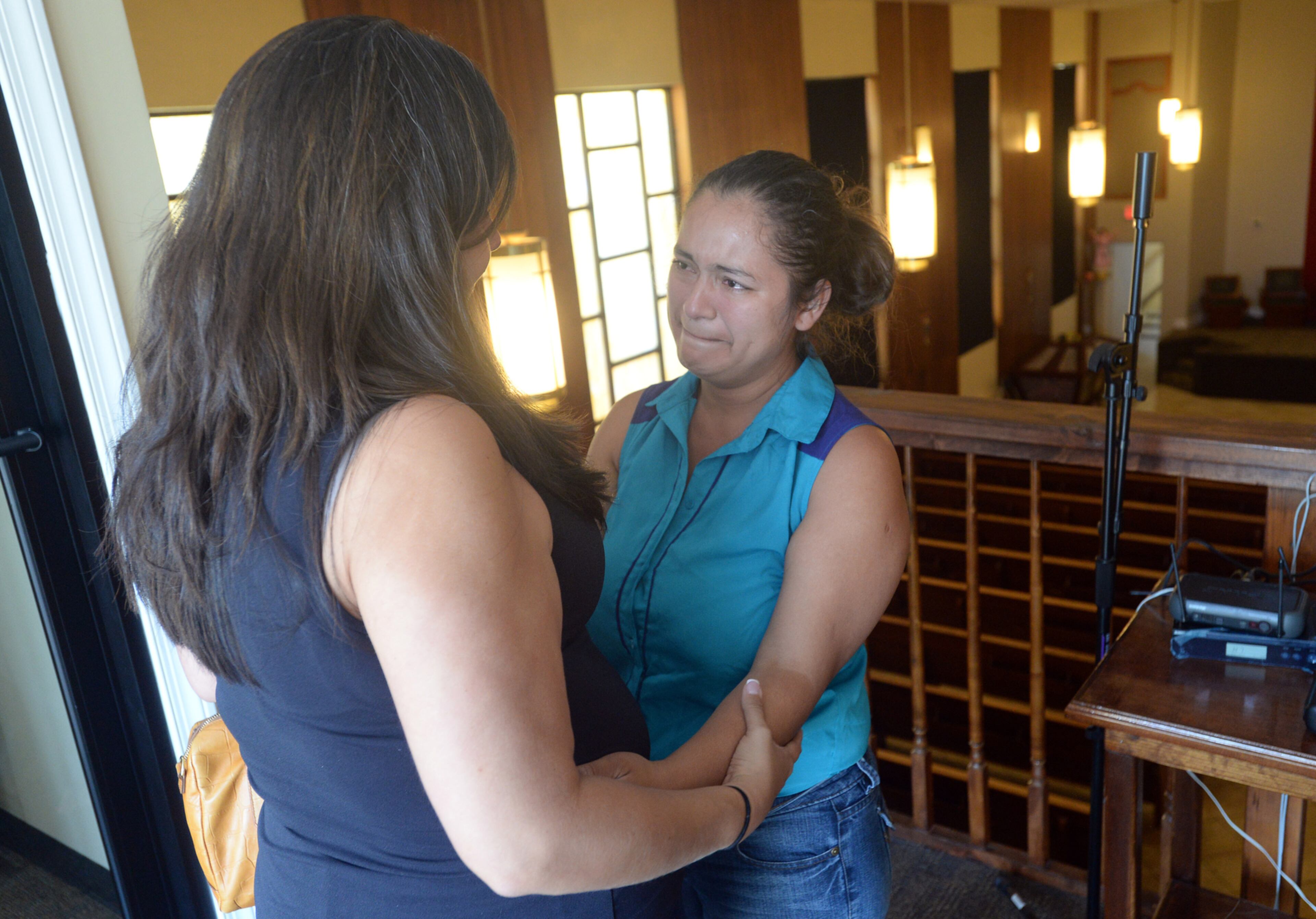 MOTHER TAKES REFUGE--AUGUST 2, 2015 LILBURN Claudia Mariela Jurado (right) gets a hug from Claudia Valenzuela, El Salvadoran Consul General at Our Lady of the Americas Catholic Mission in Lilburn Sunday, August 2, 2015. Jurado, a pregnant El Salvadorian woman who has been ordered deported for illegally entering the U.S., has fled to an Atlanta-area Catholic mission, where she is seeking sanctuary with her two young children. Jurado recently cut off the electronic monitoring bracelet immigration authorities had attached to her ankle. She absconded after she was asked to report to them Friday for her removal. Now living in a converted office at Our Lady of the Americas Catholic Mission in Lilburn, Jurado said she left El Salvador because a gang extorted money from her there. A Catholic, she said she will stay at the mission until “God decides” otherwise. “I’m afraid for my life,” she said through an interpreter Sunday about the possibility of returning to her native country. KENT D. JOHNSON /KDJOHNSON@AJC.COM