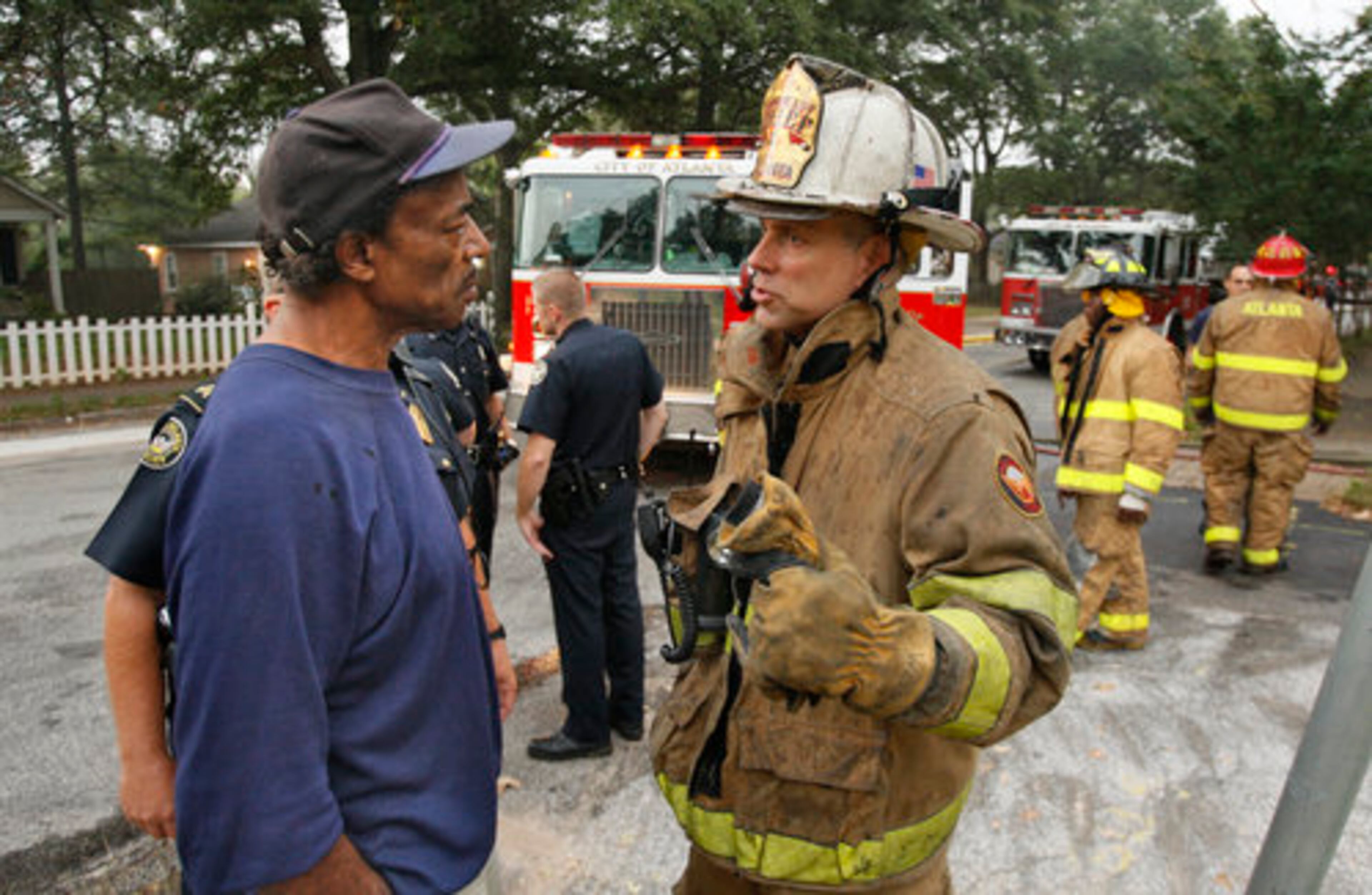 Edward Heath (left) , who has lived in the neighborhood since the 1970's, talks with Atlanta Assistant Fire Chief Chris Wessels about the residents who were initially feared dead.