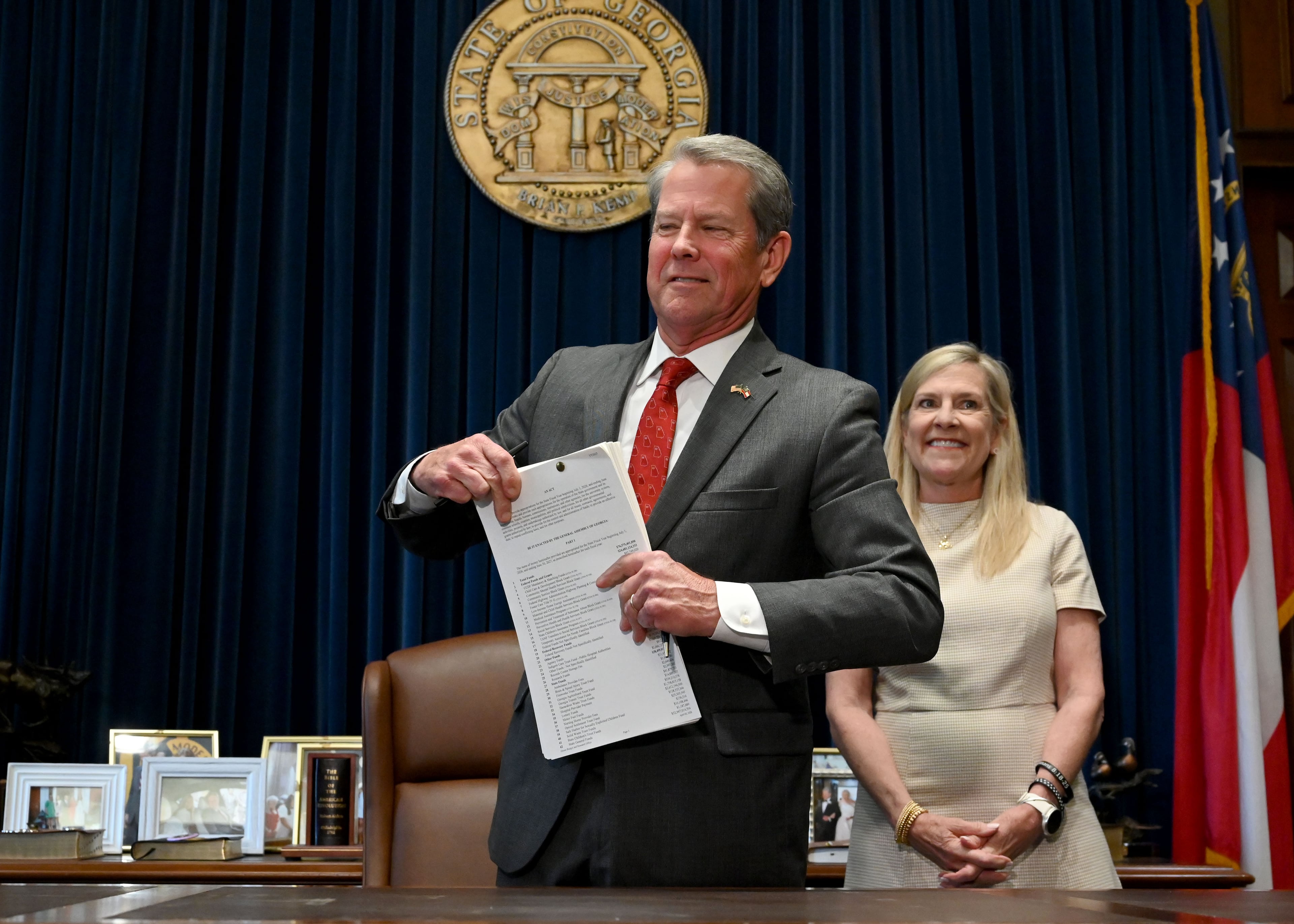 Gov. Brian Kemp and first lady Marty Kemp react after the governor signed the state's new budget on Tuesday. (Hyosub Shin/AJC)