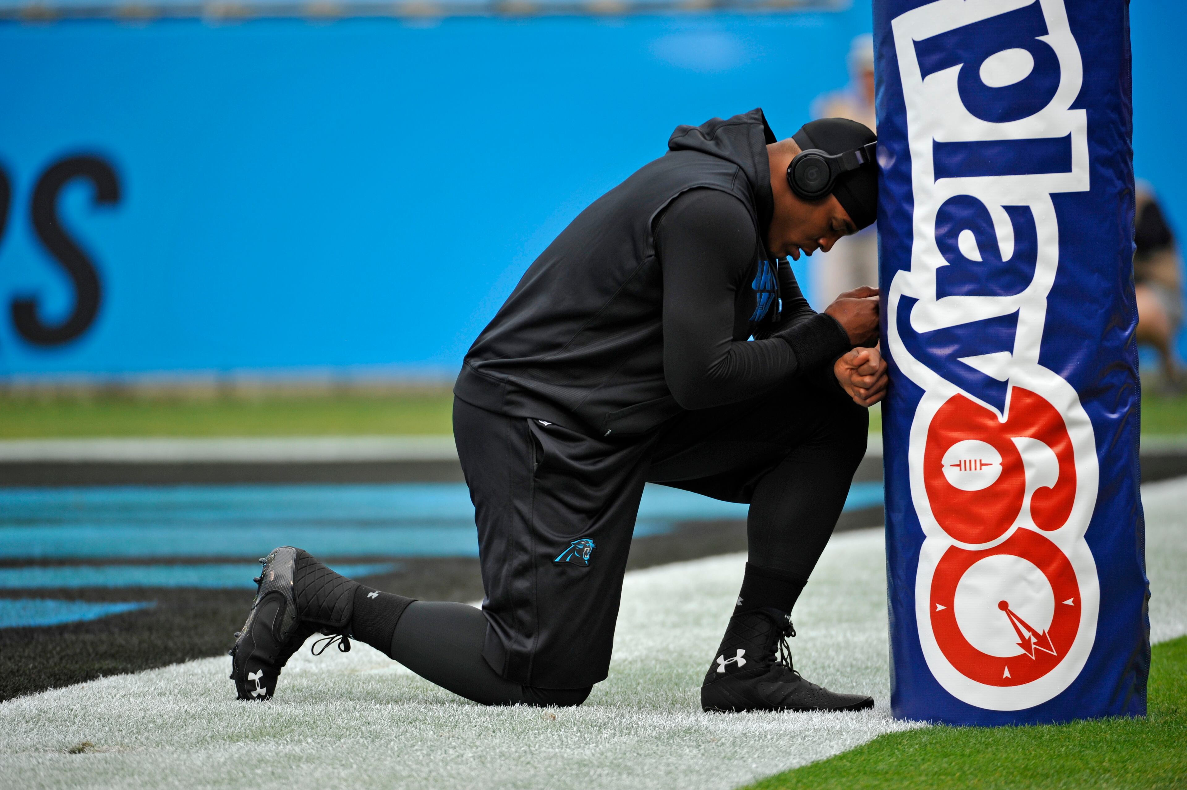 Carolina Panthers' Cam Newton pauses at a goal post as he warms up before an NFL football game against the Atlanta Falcons in Charlotte, N.C., Sunday, Dec. 9, 2012.