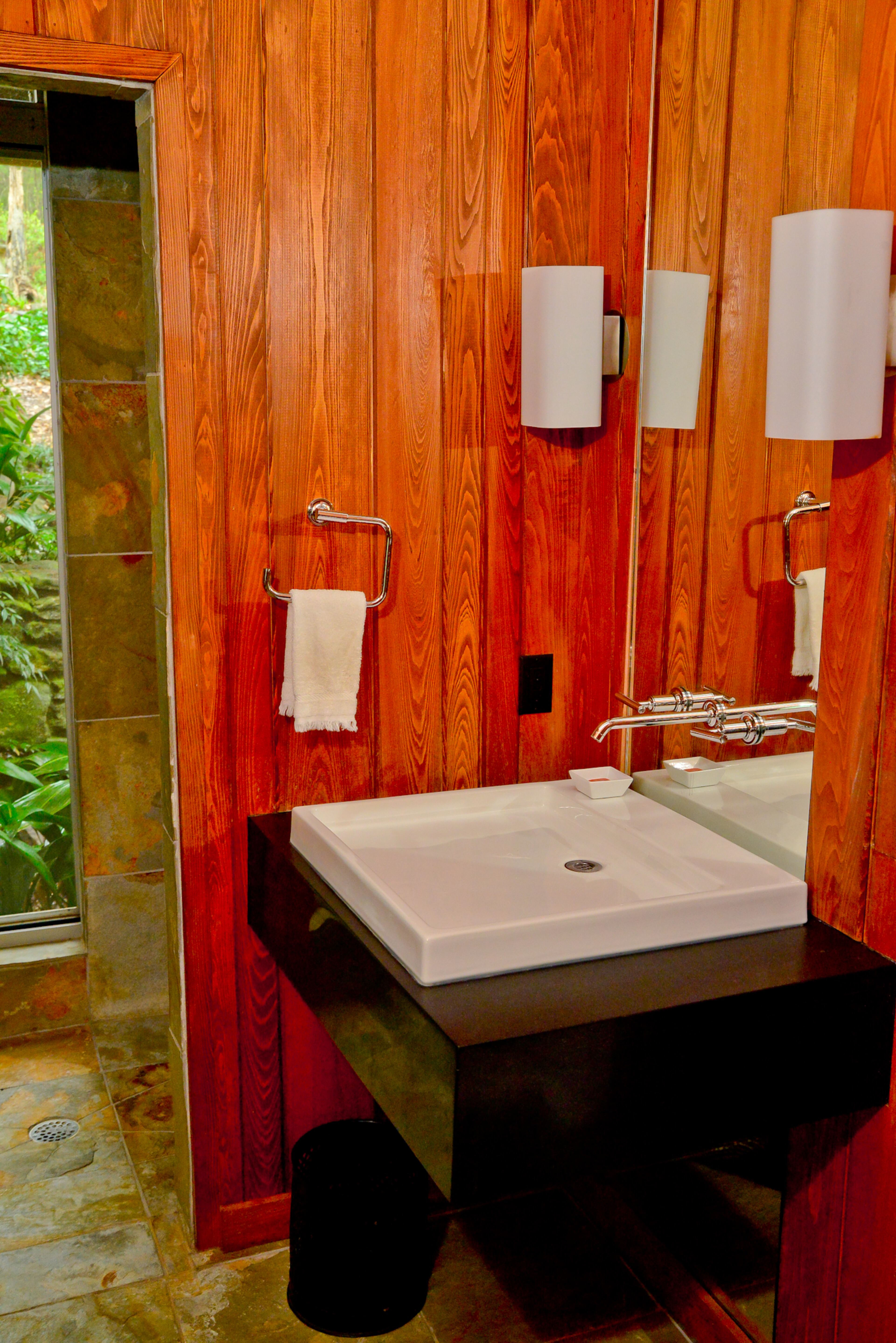 The homeowner's son, Warren McConaughey of HammerSmith, added a downstairs bedroom and full bath with elements such as a honed granite vanity, so that his parents could age in place in the home.