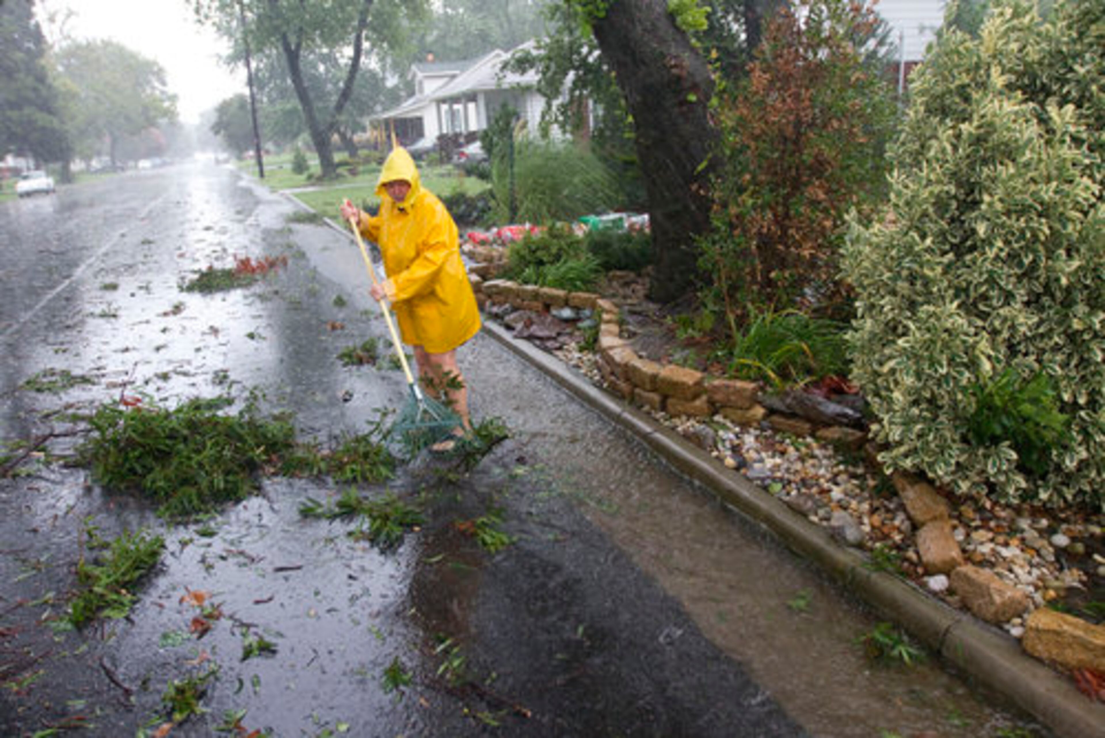 Rhonda Woods cleans up a drainage area near her house as Hurricane Irene approaches the Hampton, Va., area.