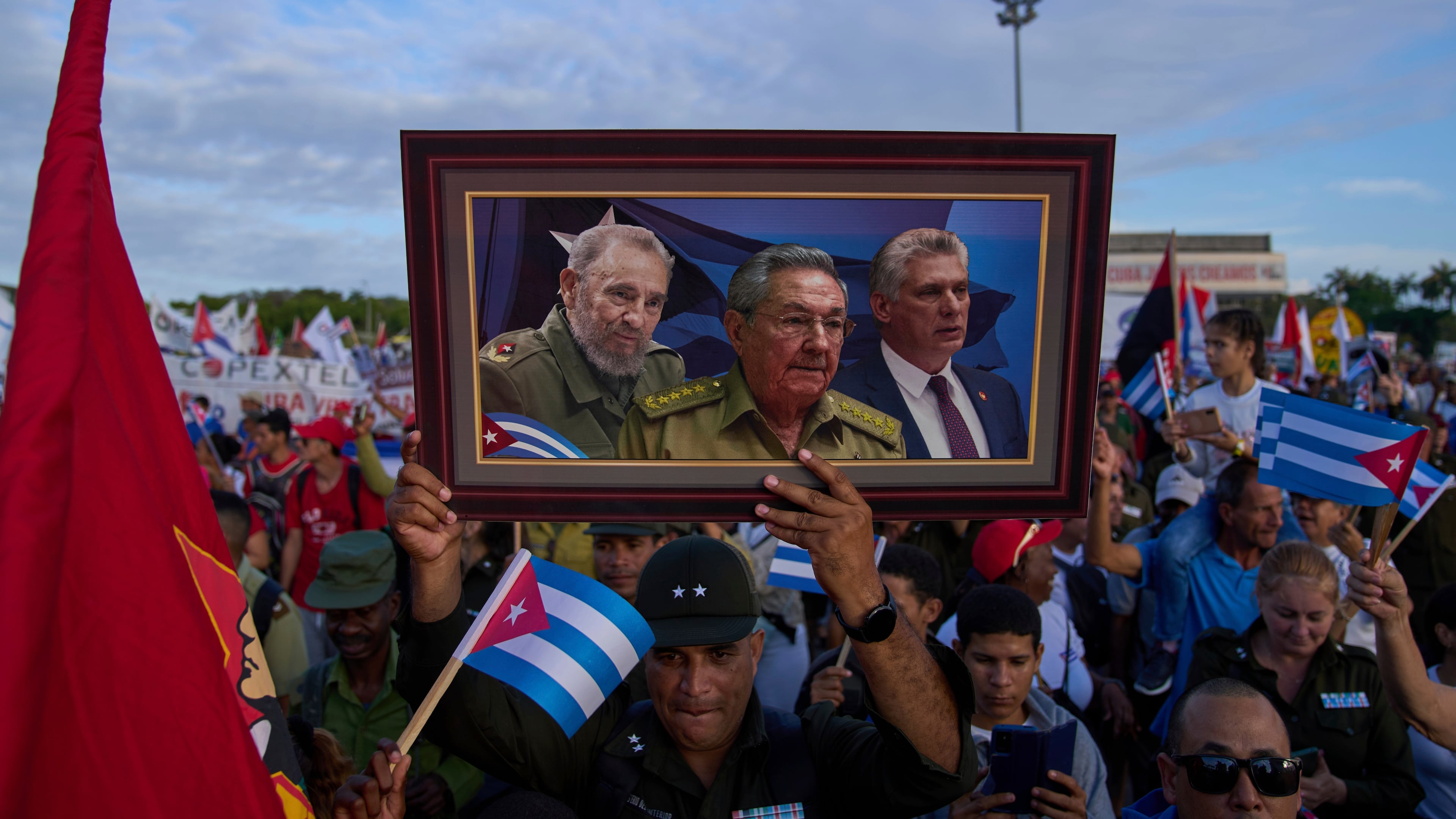 FILE - A marcher holds a framed composite image of Fidel Castro, Raul Castro and Cuba's President Miguel Diaz-Canel, during the May Day parade at Revolution Square in Havana, May 1, 2025. (AP Photo/Ramon Espinosa, File)