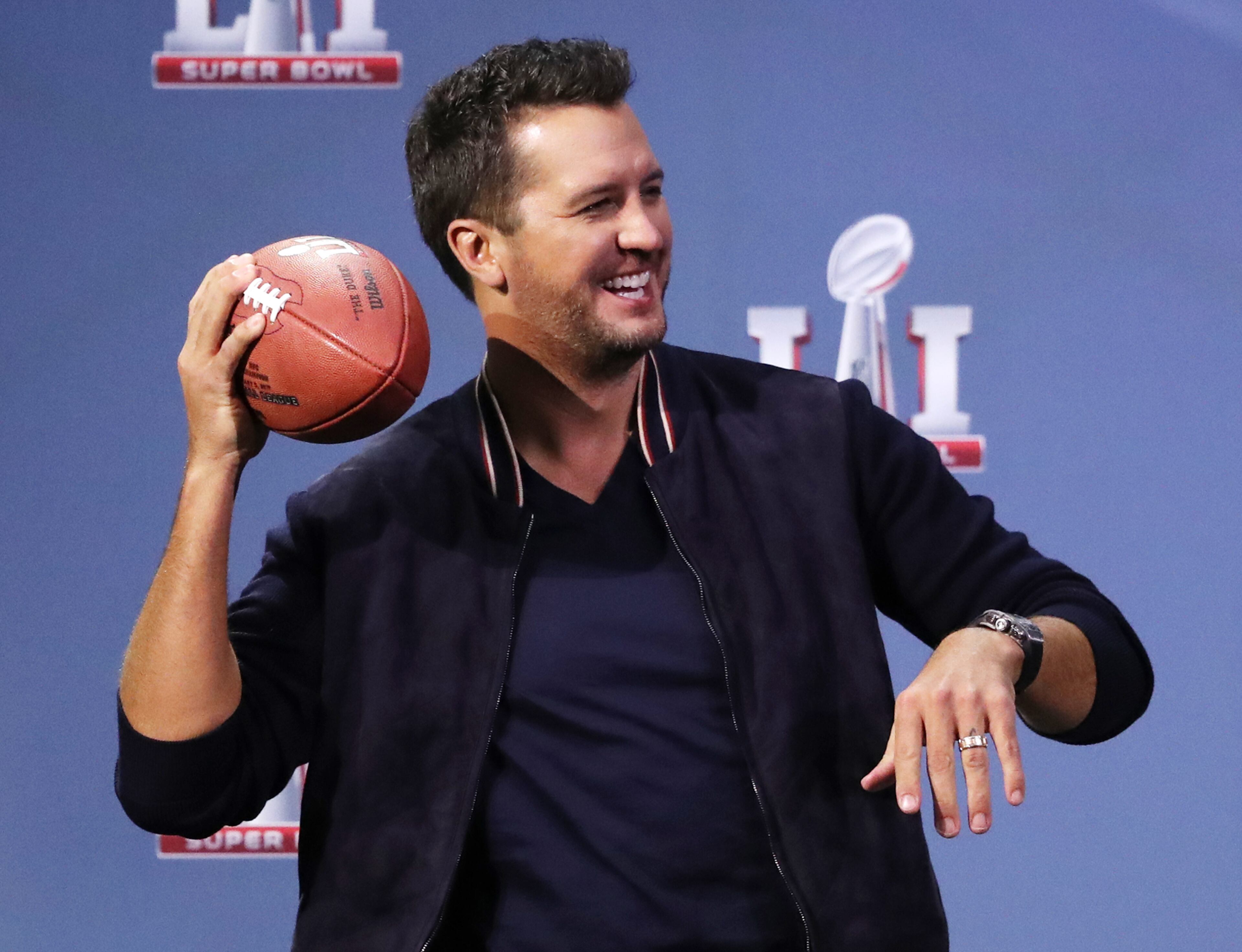 Luke Bryan 'drops back to pass' during the press conference.