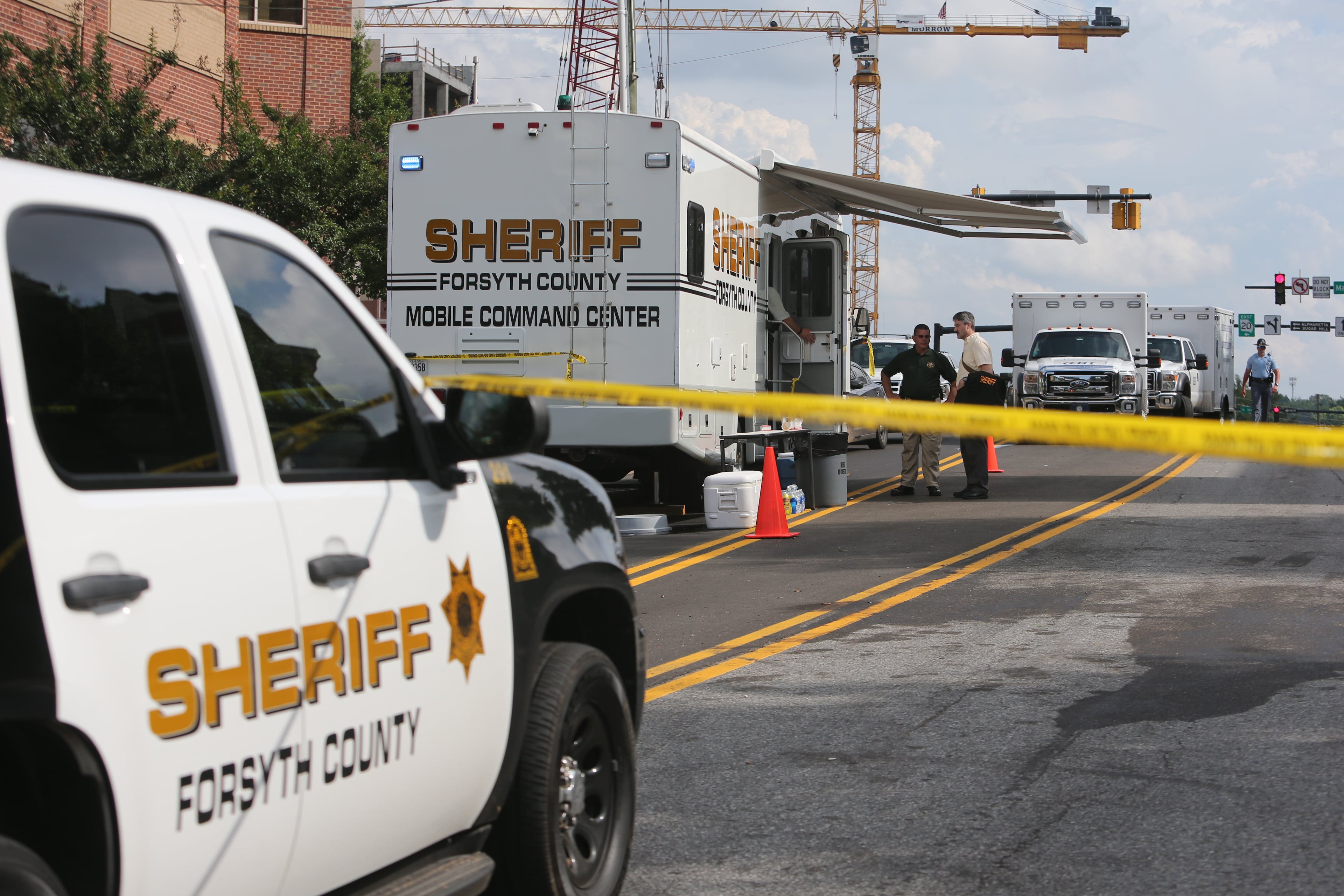 Authorities investigate the scene of shooting that took place in front of the Forsyth County courthouse in Cumming, Ga., on June 6, 2014.