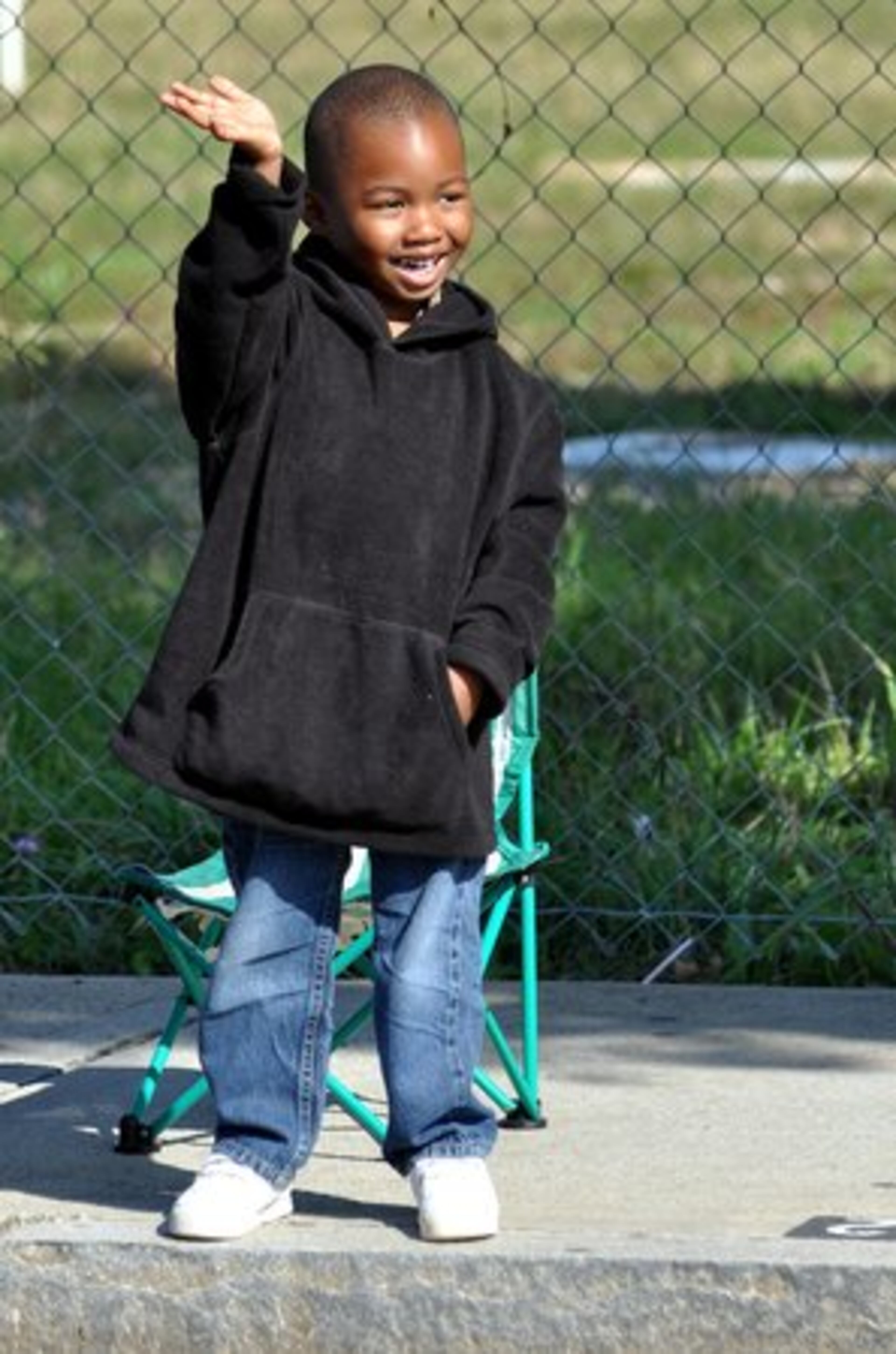 4-year old Dallas Harris of Austell waves to his favorite marching bands and dance teams during the parade.