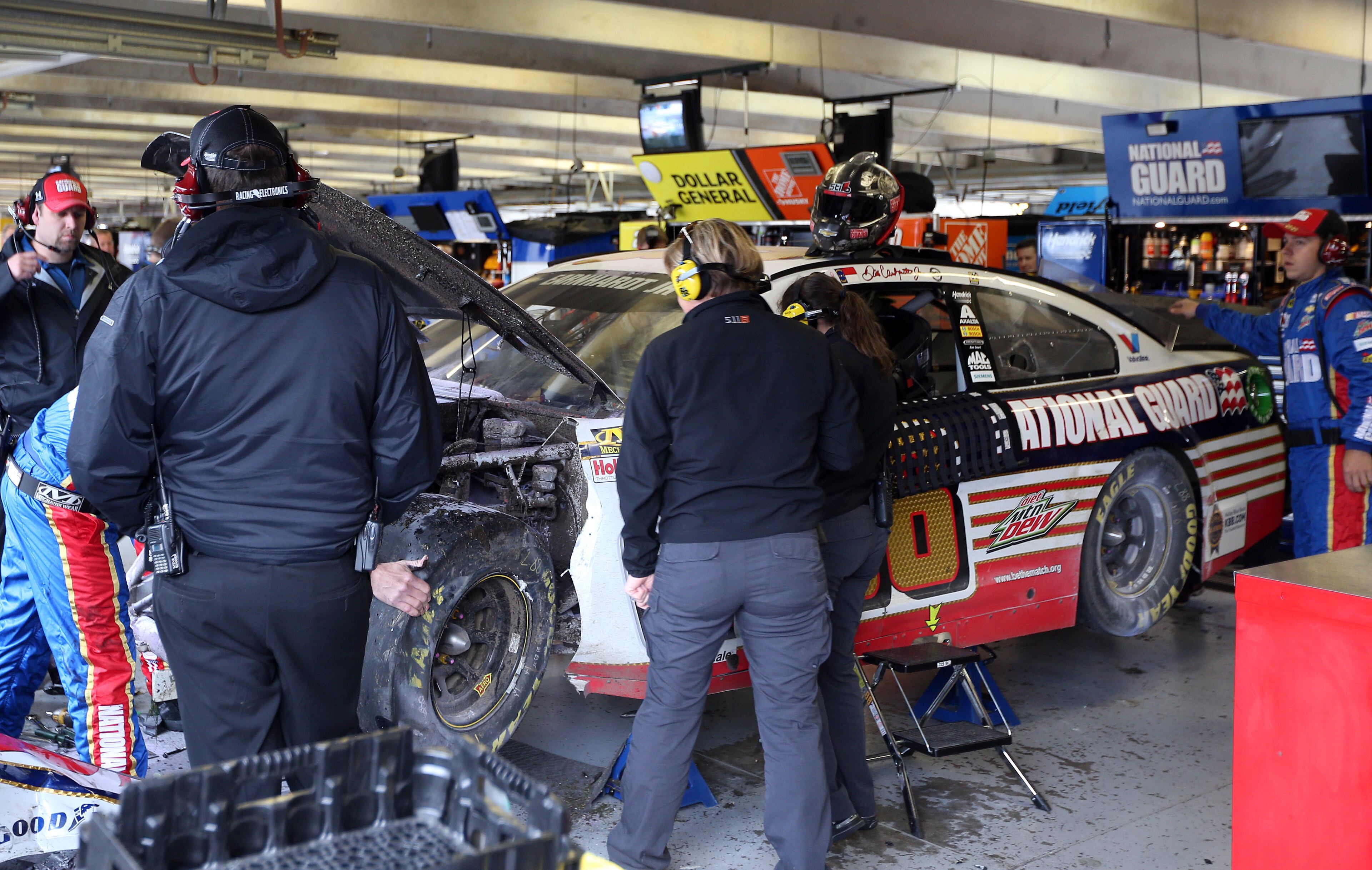 Crew members work on the #88 National Guard Chevrolet of Dale Earnhardt Jr. in the garage area after he crashed early in the NASCAR Sprint Cup Series Duck Commander 500 at Texas Motor Speedway on April 7, 2014 in Fort Worth, Texas. (Photo by Chris Graythen/Getty Images for Texas Motor Speedway)