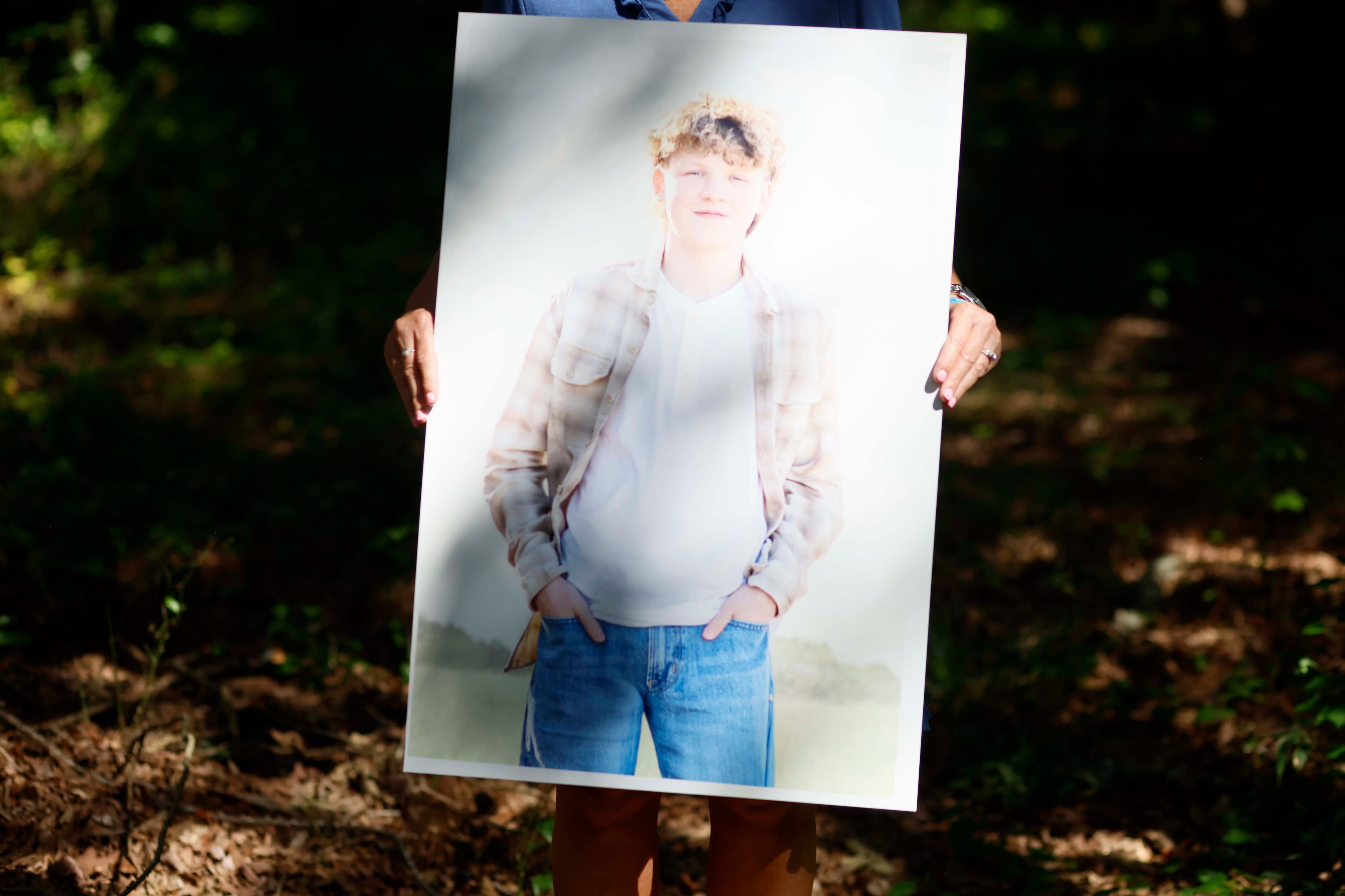 Ashley Worthey holds a portrait of her son, Mason Worthey, at her house in Good Hope, Ga., on Sunday, Aug. 9, 2026. The portrait was displayed at his funeral. (Miguel Martinez/AJC)