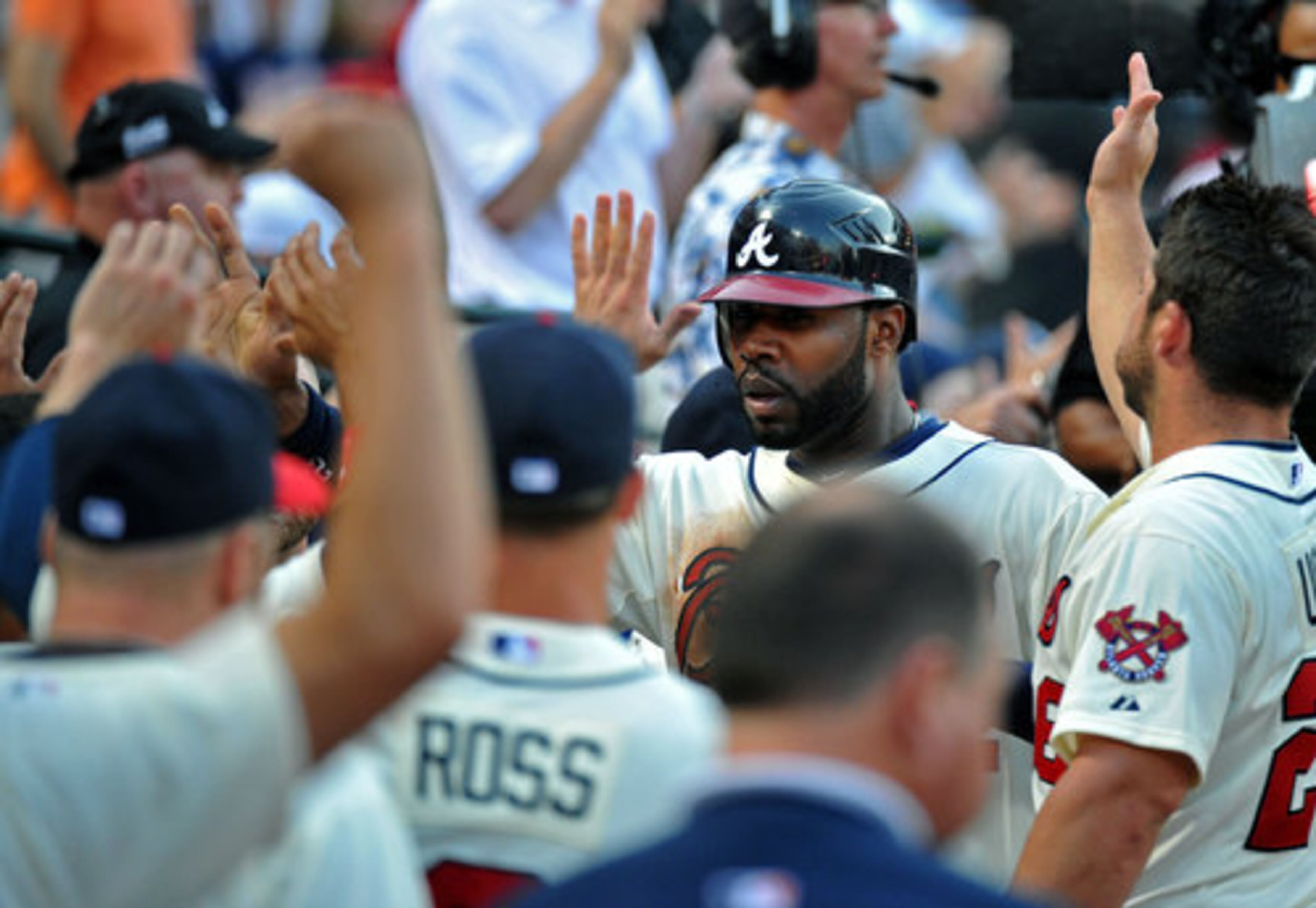Atlanta Braves right fielder Jason Heyward (22) is congratulated by teammates after he scored on an RBI double by Atlanta Braves third baseman Juan Francisco (25) in the second inning at Turner Field in Atlanta on Saturday, April 14, 2012.