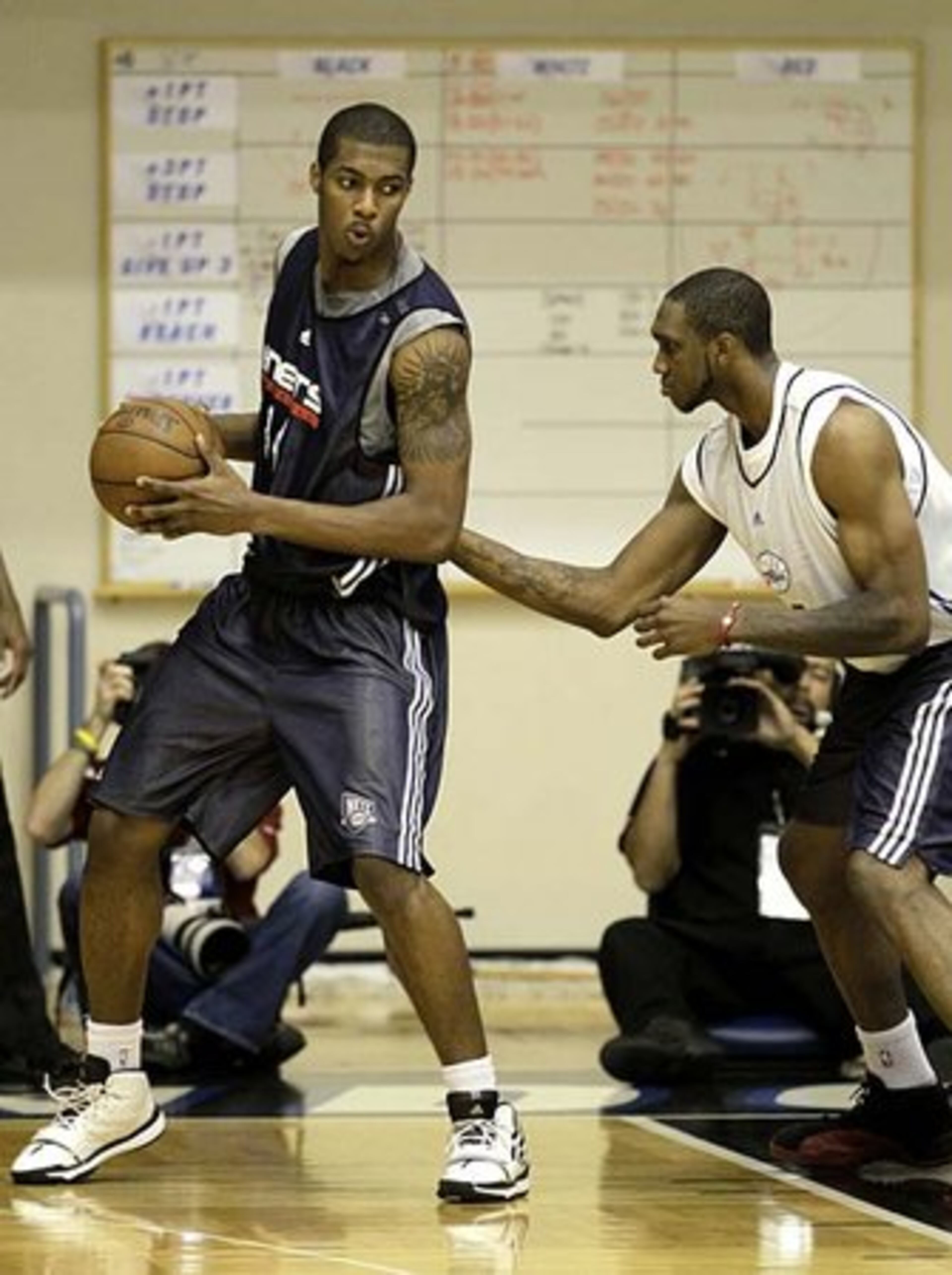 Philadelphia's Cedric Simmons (right) works to defend against Favors in first half action.