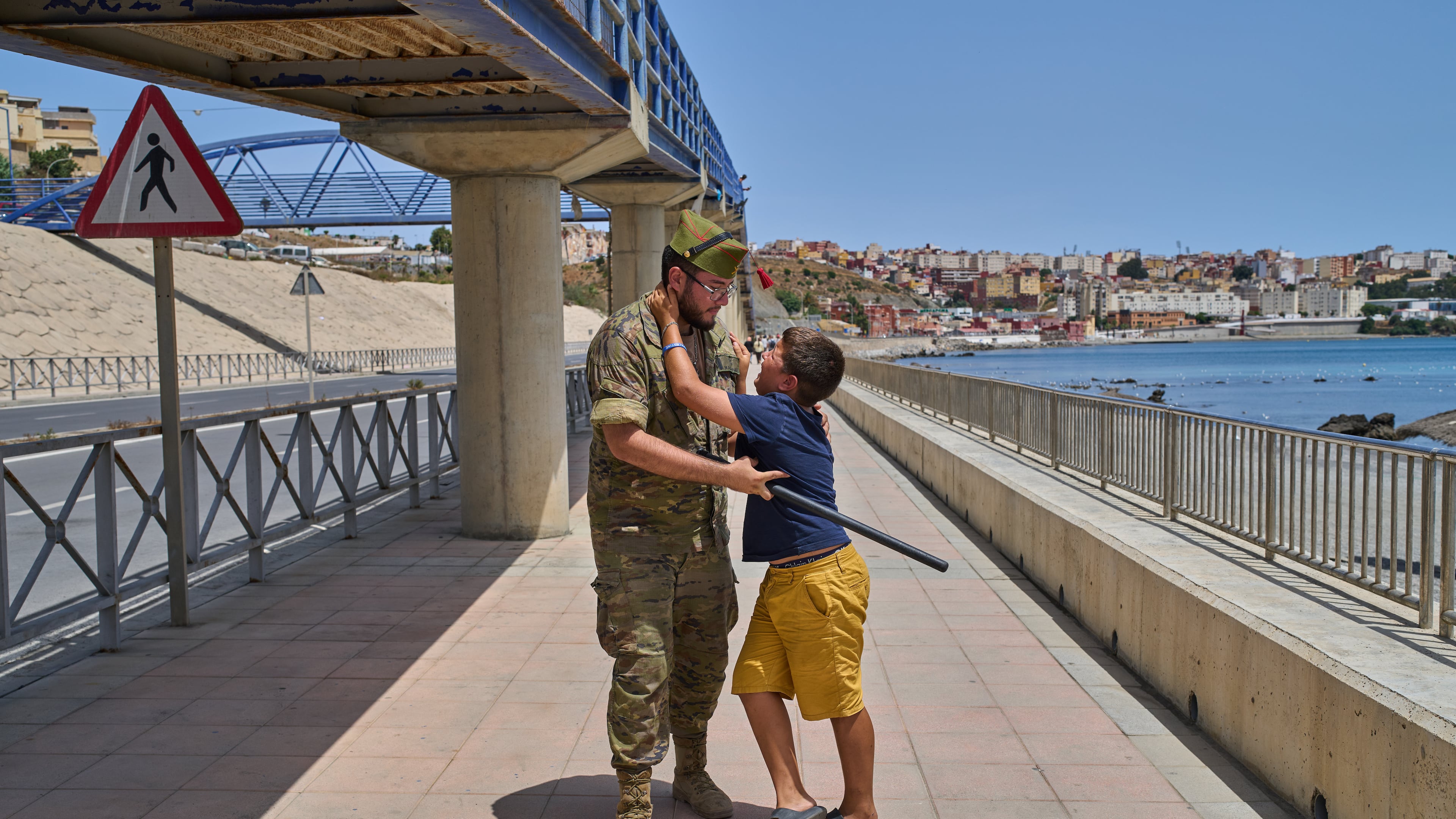 A 12-year-old unaccompanied minor who crossed into Spain is escorted by a Spanish soldier to the Spain-Morocco border as the child begs not to be sent back to Morocco from the Spanish enclave of Ceuta, Monday, Aug. 3, 2026. The forced deportation of the unaccompanied minor was stopped by a high-ranking official a few meters before the child reached the border after residents and journalists said the migrant was a minor. (AP Photo/Bernat Armangue)