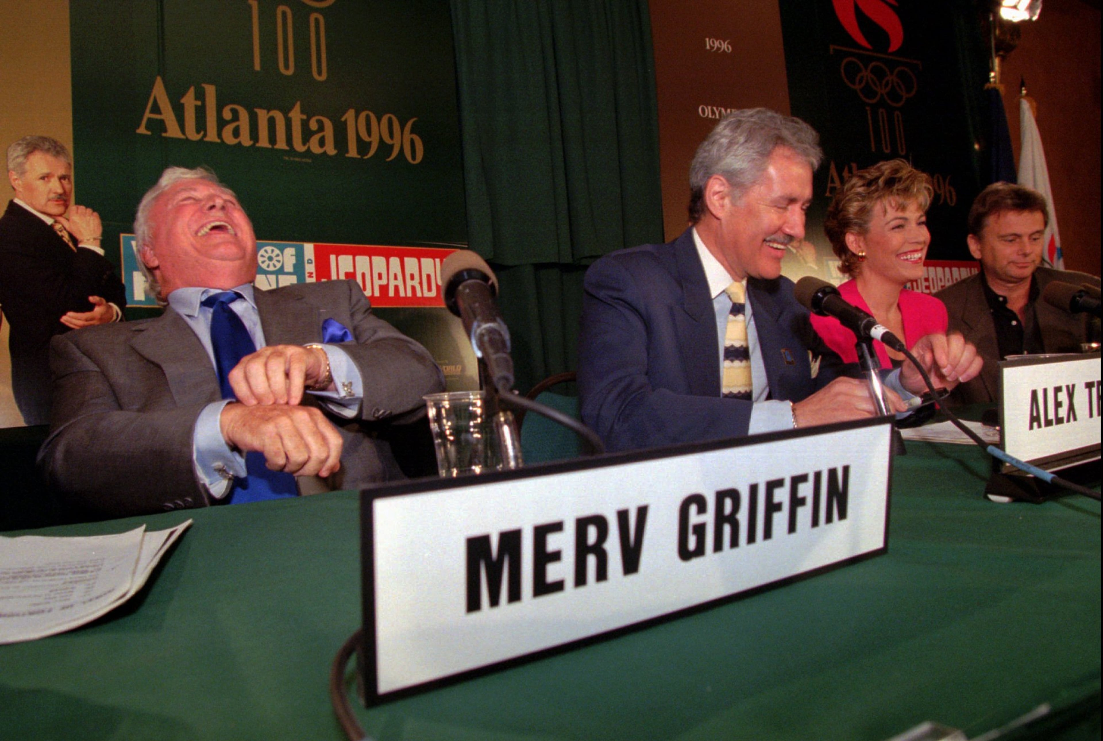 Game show creator Merv Griffin, left, shares a laugh with "Jeopardy!" host Alex Trebek, second from left, and "Wheel of Fortune" hosts Vanna White and Pat Sajak, right, during a news conference in Atlanta Thursday, March 28, 1996 to announce their Olympic marketing plans. The popular game shows are Olympic sponsors and begining in April will launch major Olympic promotions and offer Olympic-related merchandise to their viewers.