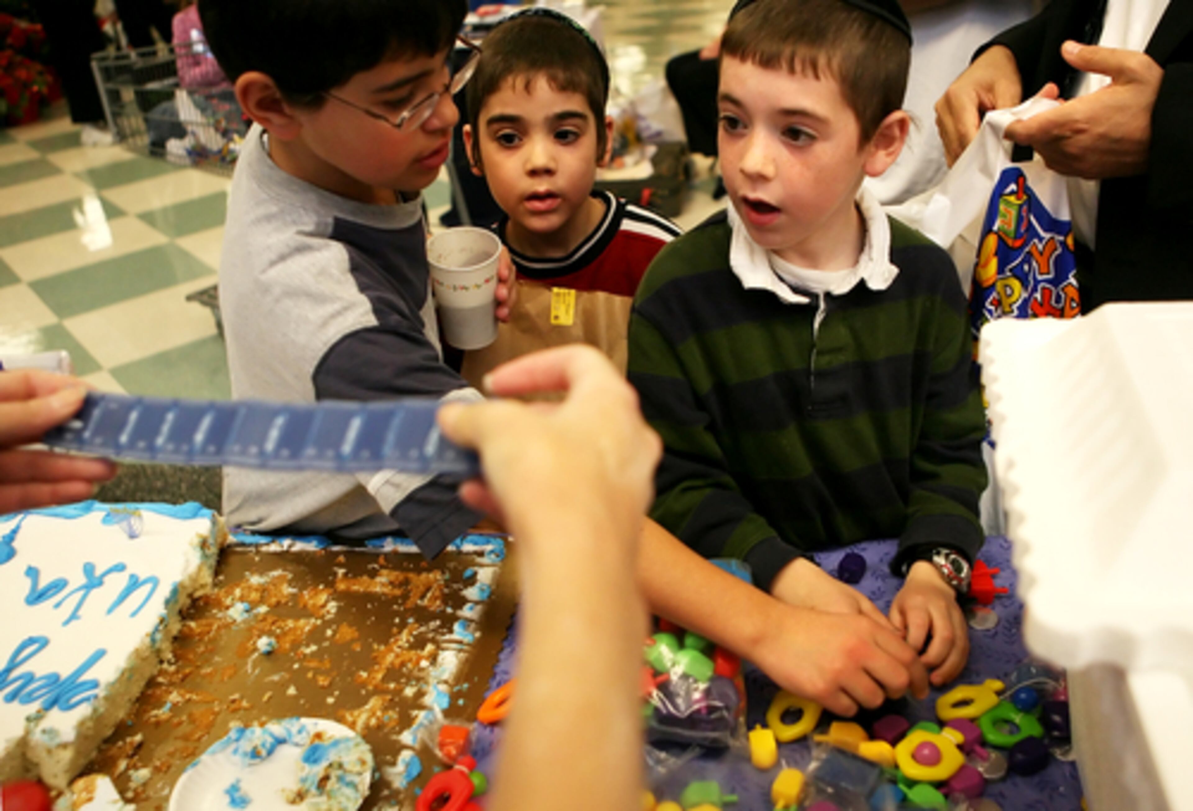 Shalom Tendler , right, checks out the free offerings at the Hanukkah celebration.