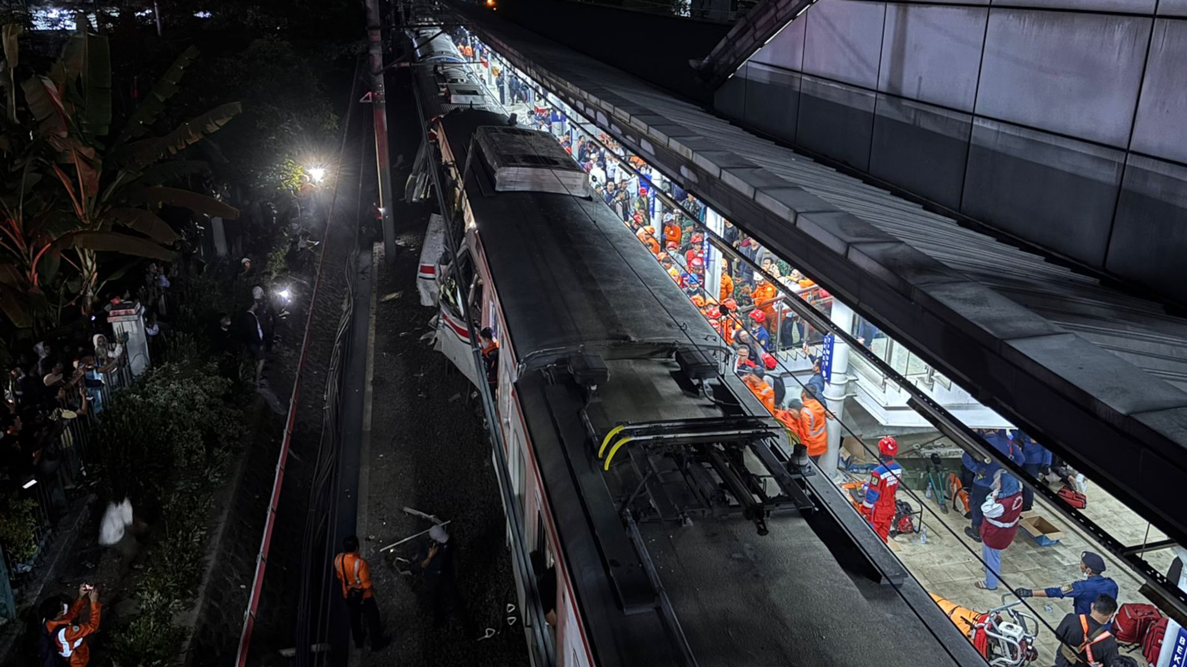 Rescuers search for victims after a train collision at a station in Bekasi, Indonesia, Monday, April 27, 2026. (AP Photo/Achmad Ibrahim)