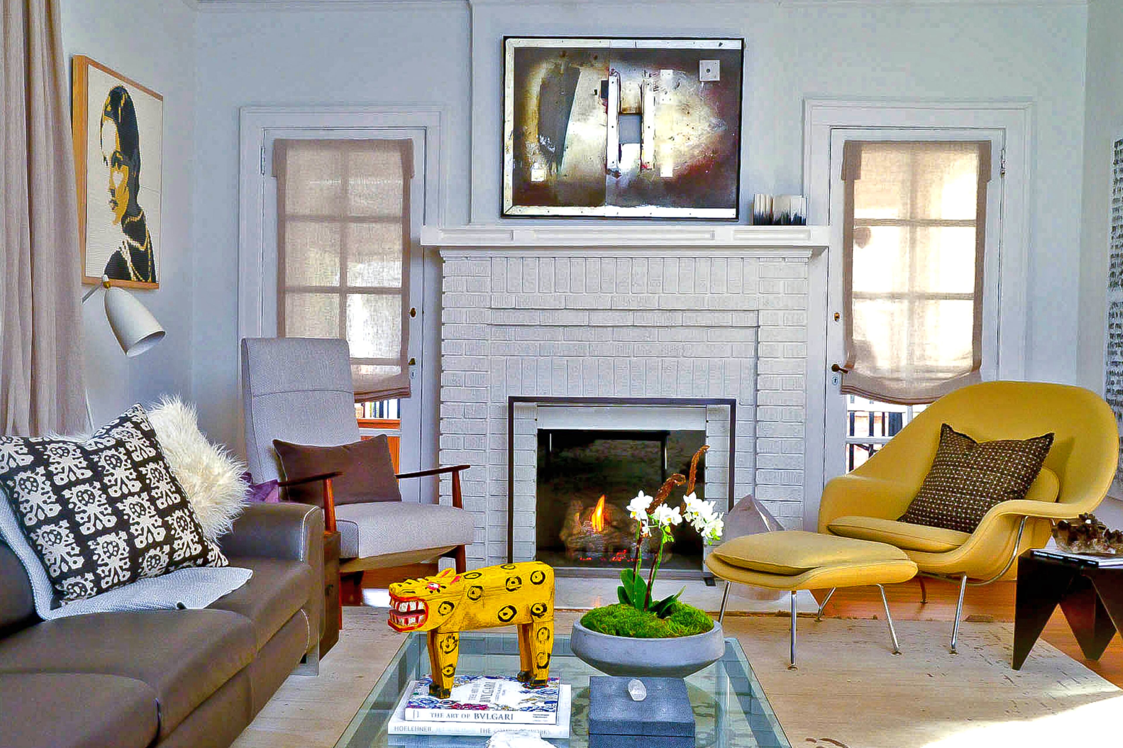 The steel photographic collage above the fireplace is by Tanya Quick, the homeowner's design school classmate. The modern Biella sofa is from Cantoni and rug is from Verde Home.