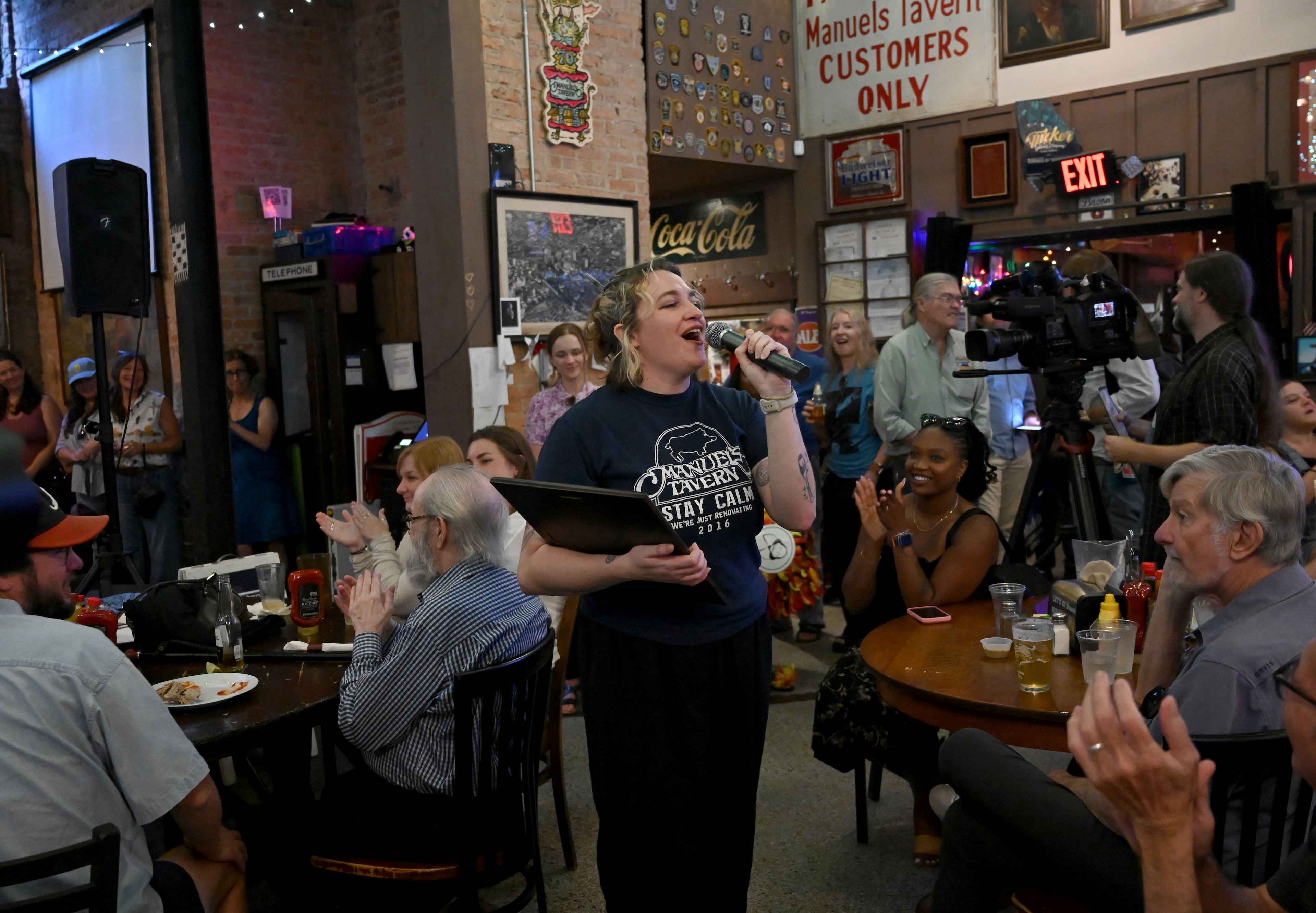 Megan Maloof (center), granddaughter of the original owner, speaks to guests during Manuel’s Tavern’s 70th anniversary celebration. (Hyosub Shin/AJC)