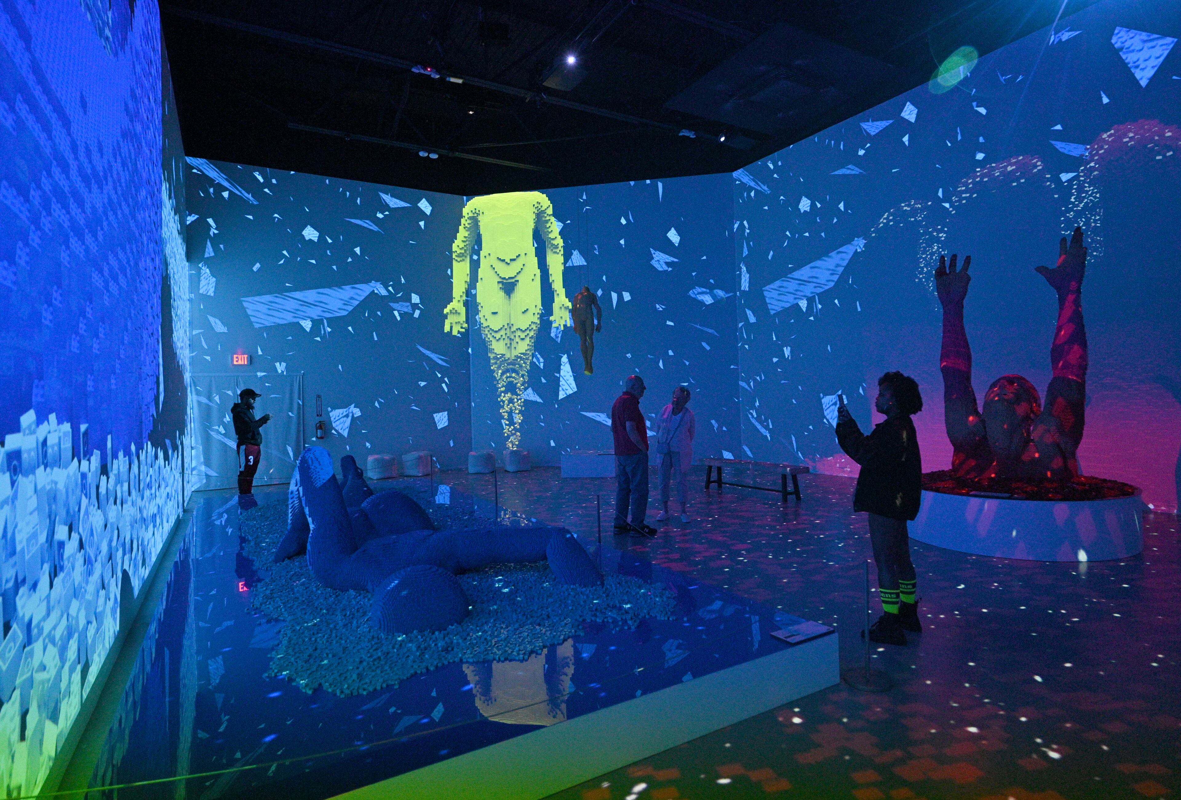 Visitors view in “Larger Than Life” room at "Art of the Brick Immersive Experience" exhibition at Exhibition Hub Atlanta Art Centre, Wednesday, April 19, 2023, in Doraville. The exhibition will feature many pieces and themes, including a room with oversized sculptures (25-foot long), over 70 works of art crafted from more than 1 million LEGO bricks, galleries celebrating human-kind and nature, and a short documentary about how Nathan creates his works. (Hyosub Shin / Hyosub.Shin@ajc.com)