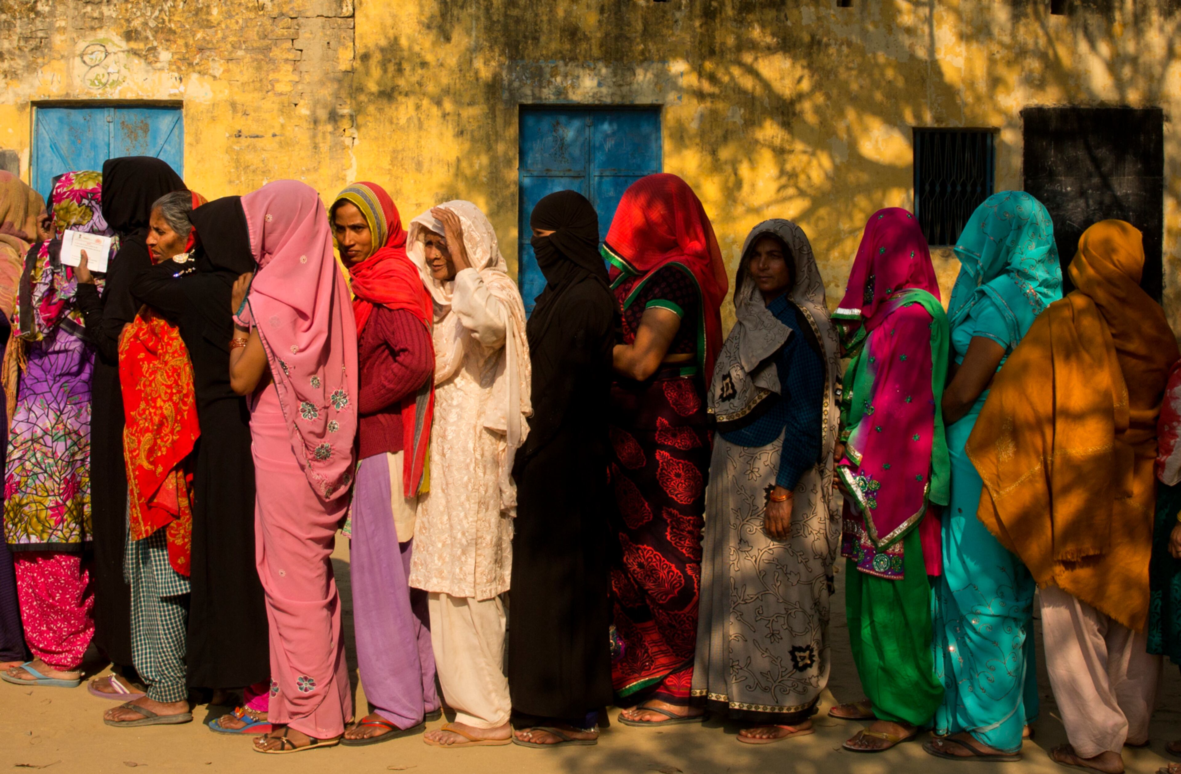 Indian women stand in a queue to cast their votes at a village near Amroha in Uttar Pradesh, India, Wednesday, Feb. 15, 2017. Uttar Pradesh and four other Indian states are having state legislature elections in February-March, a key mid-term test for Prime Minister Narendra Modi's Hindu nationalist government which has been ruling India since 2014. (AP Photo/Manish Swarup)