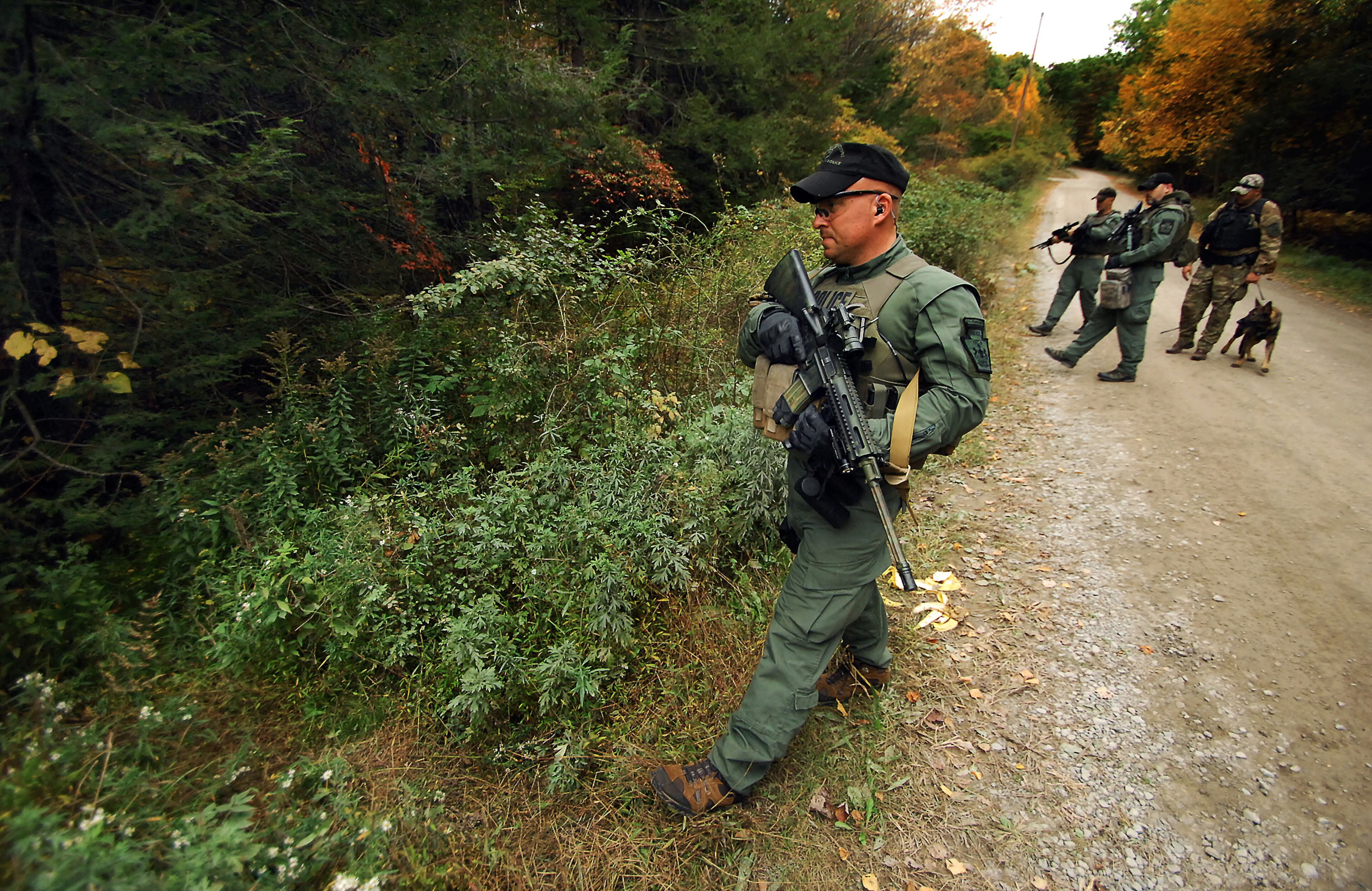 A member of the Scranton, Pa., Police Special Operations Group, prepares to ender the woods, Thursday, Oct. 2, 2014, in Barrett Township near Canadensis, Pa., to search for suspected killer Eric Frein. A massive manhunt has been underway for 31-year-old Frein in the rugged terrain of the Pocono Mountains since Sept. 12. The self-taught survivalist is charged with killing Cpl. Bryon Dickson and seriously wounding Trooper Alex Douglass outside their barracks in Blooming Grove. (AP Photo/Scranton Times & Tribune, Butch Comegys) WILKES BARRE TIMES-LEADER OUT; MANDATORY CREDIT