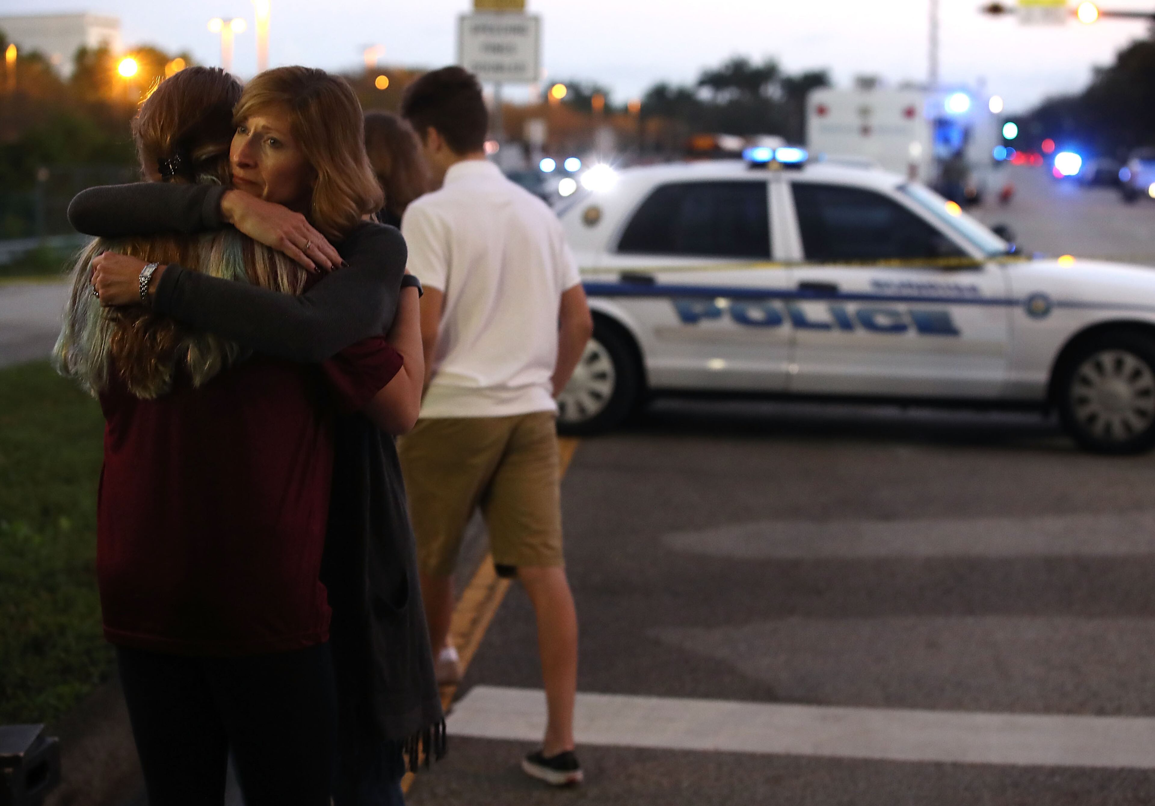 PARKLAND, FL - FEBRUARY 15: Kristi Gilroy hugs a young woman at a police check point near the Marjory Stoneman Douglas High School where 17 people yesterday were killed by a gunman on February 15, 2018 in Parkland, Florida. Police arrested the suspect after a short manhunt, and have identified him as 19-year-old former student Nikolas Cruz. (Photo by Mark Wilson/Getty Images)