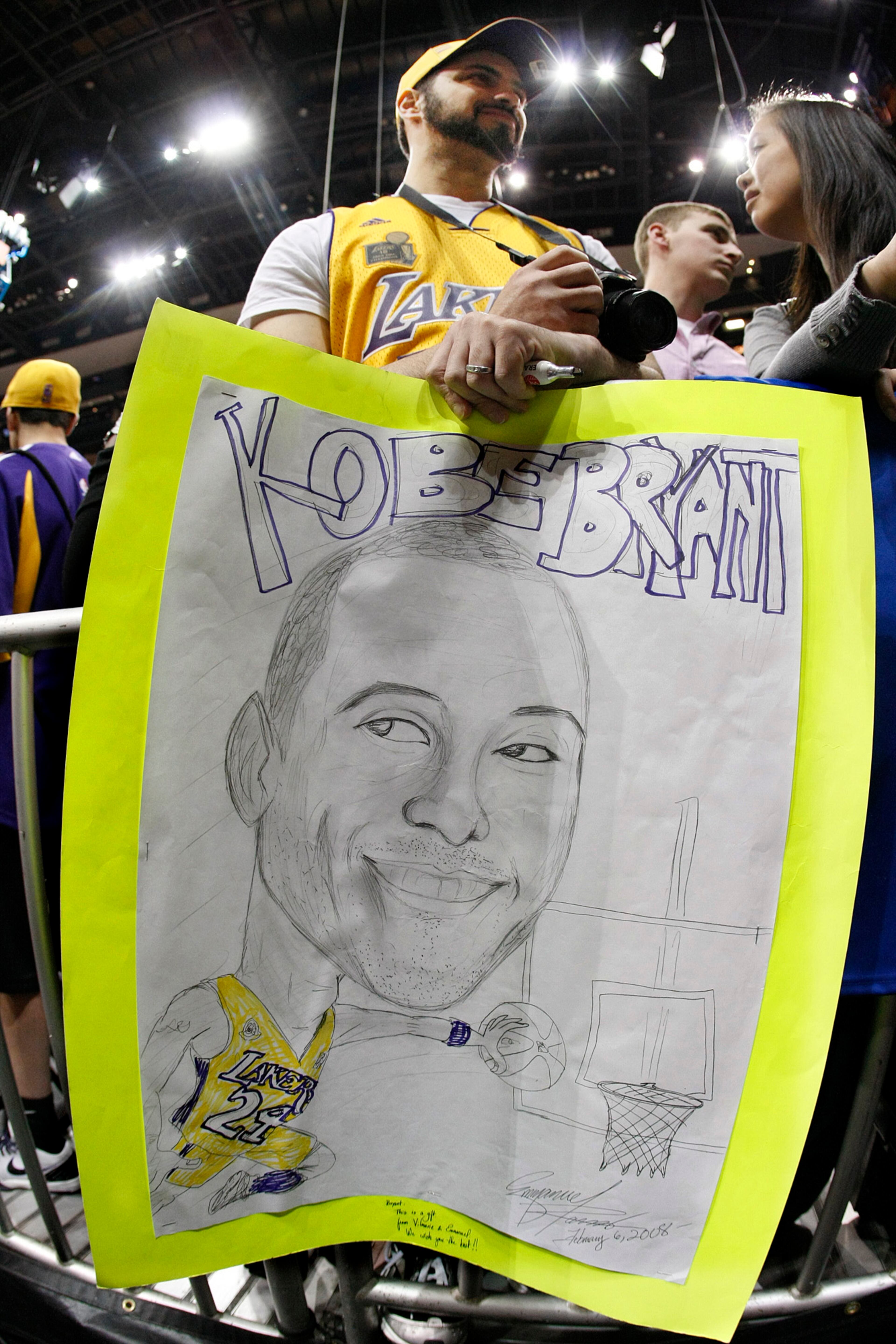 Emmanuel Ramos holds a sign for Kobe Bryant as he waits to snap a photo of him during the 2010 game at Philips Arena. (AJC file photo/Curtis Compton)