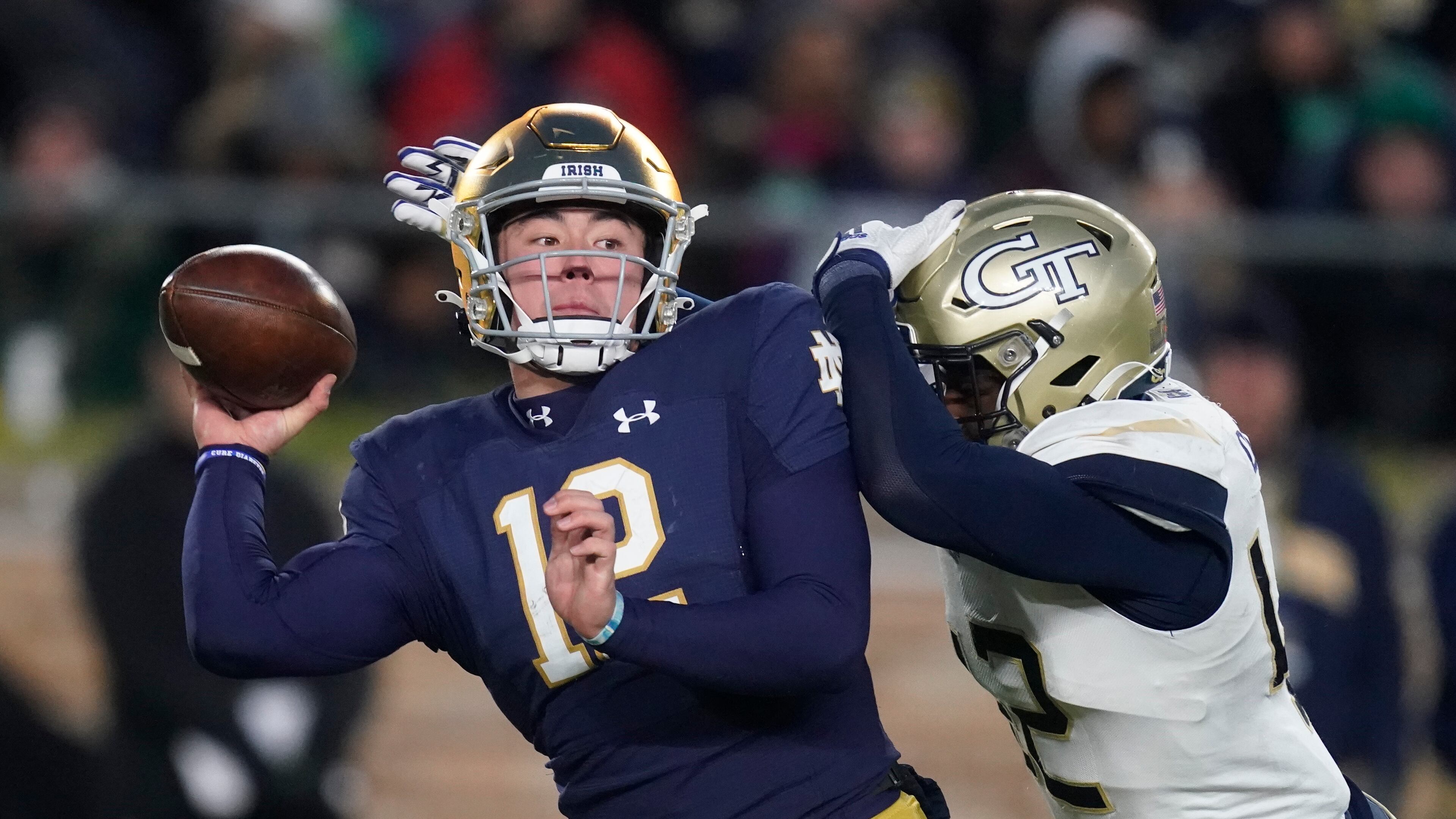 Notre Dame quarterback Tyler Buchner throws as he is hit by Georgia Tech's Jordan Domineck during a game Nov. 20 in South Bend, Indiana. Domineck, who went into the transfer portal Friday after leading the Yellow Jackets in sacks each of the past two seasons, said he is leaving Tech because he wants to become a physical therapist after his football career is over and that the institute doesn’t have the sort of degree program he’s looking for to help him in that pursuit. (AP Photo/Darron Cummings)