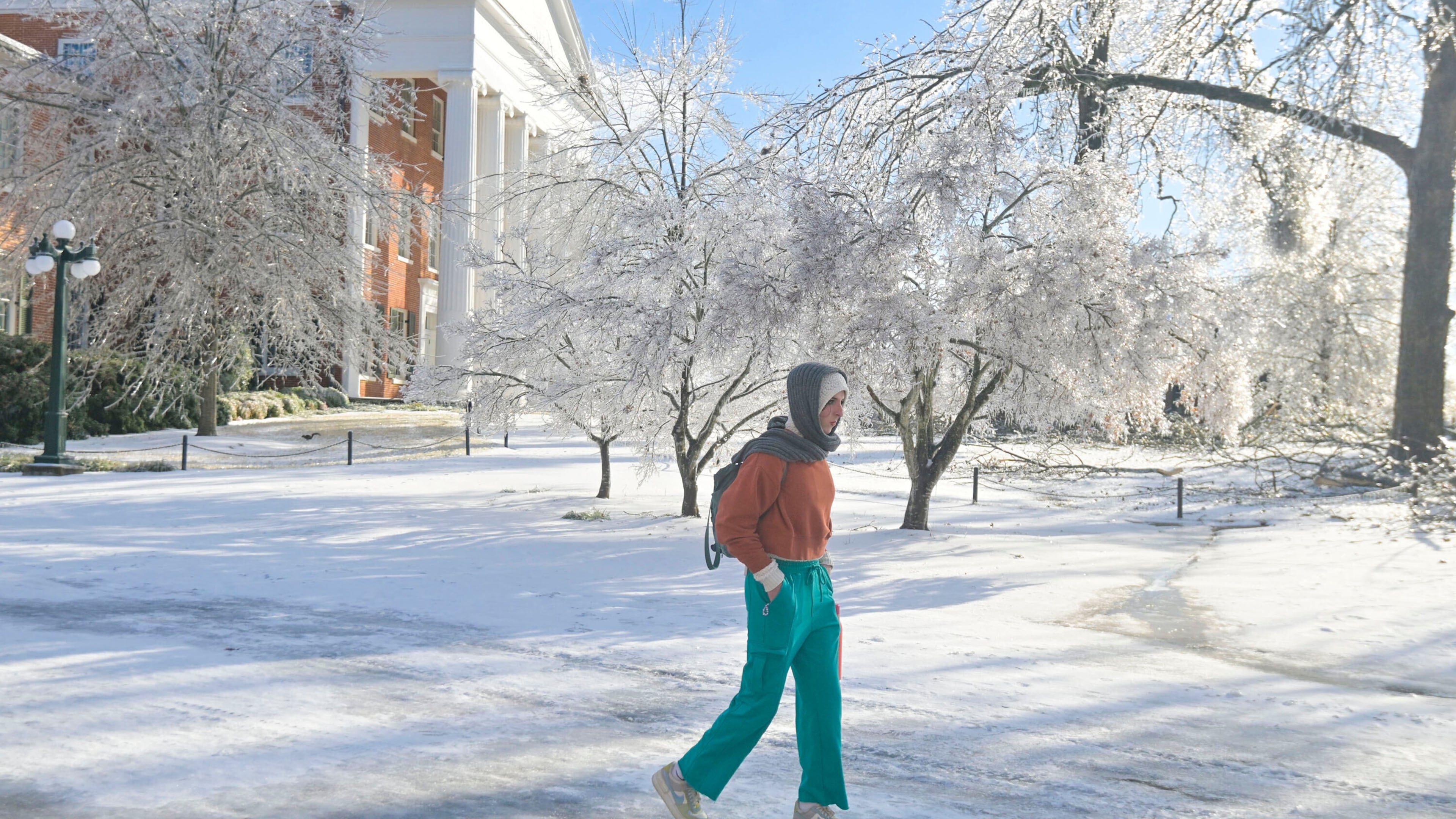 A woman walks across the campus of the University of Mississippi in Oxford, Miss. on Monday, Jan. 26, 2026, following a weekend ice storm. (AP Photo/Bruce Newman)