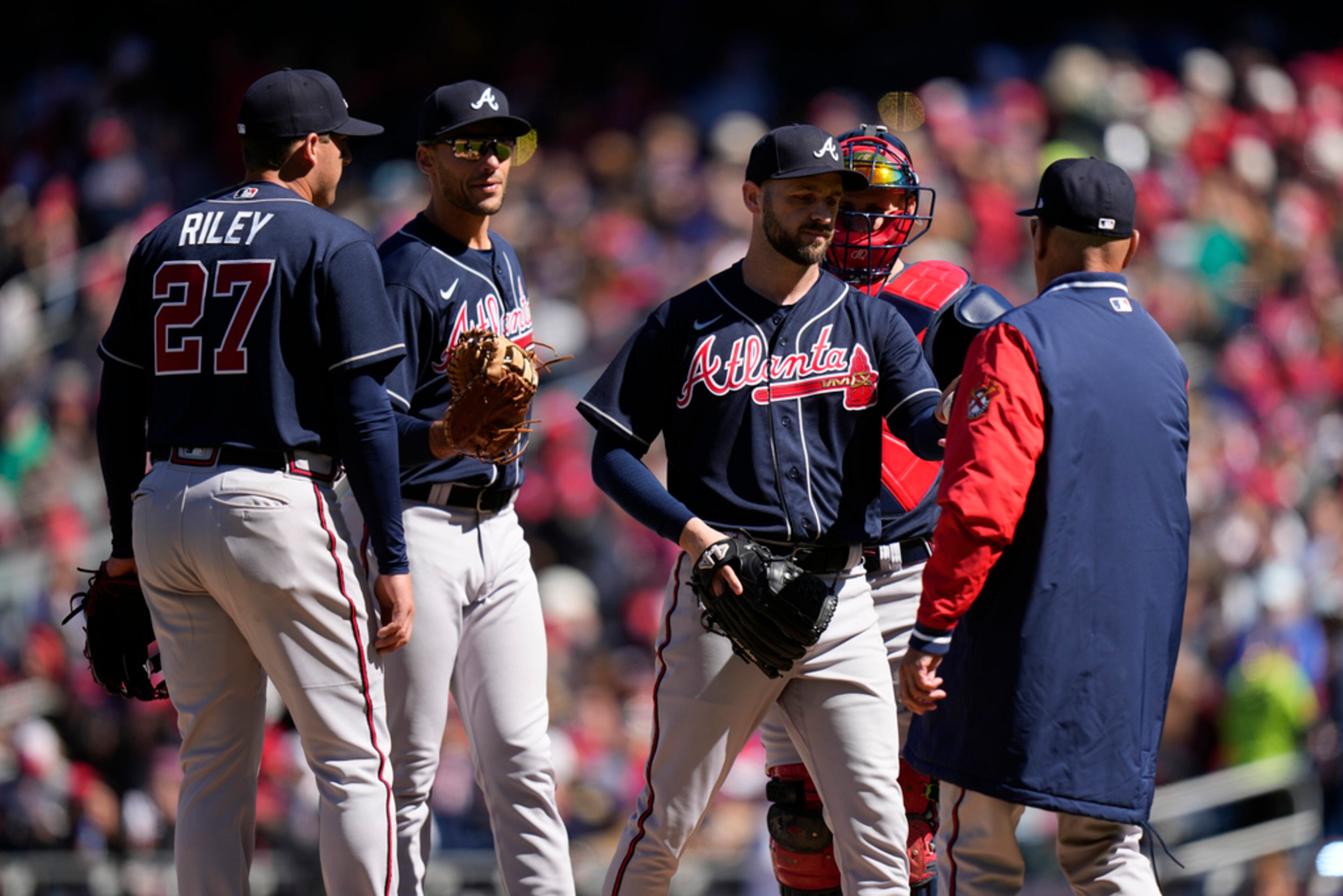 Atlanta Braves relief pitcher Lucas Luetge, center, is relieved by manager Brian Snitker, right, during the fifth inning of an opening day baseball game against the Washington Nationals at Nationals Park, Thursday, March 30, 2023, in Washington. (AP Photo/Alex Brandon)