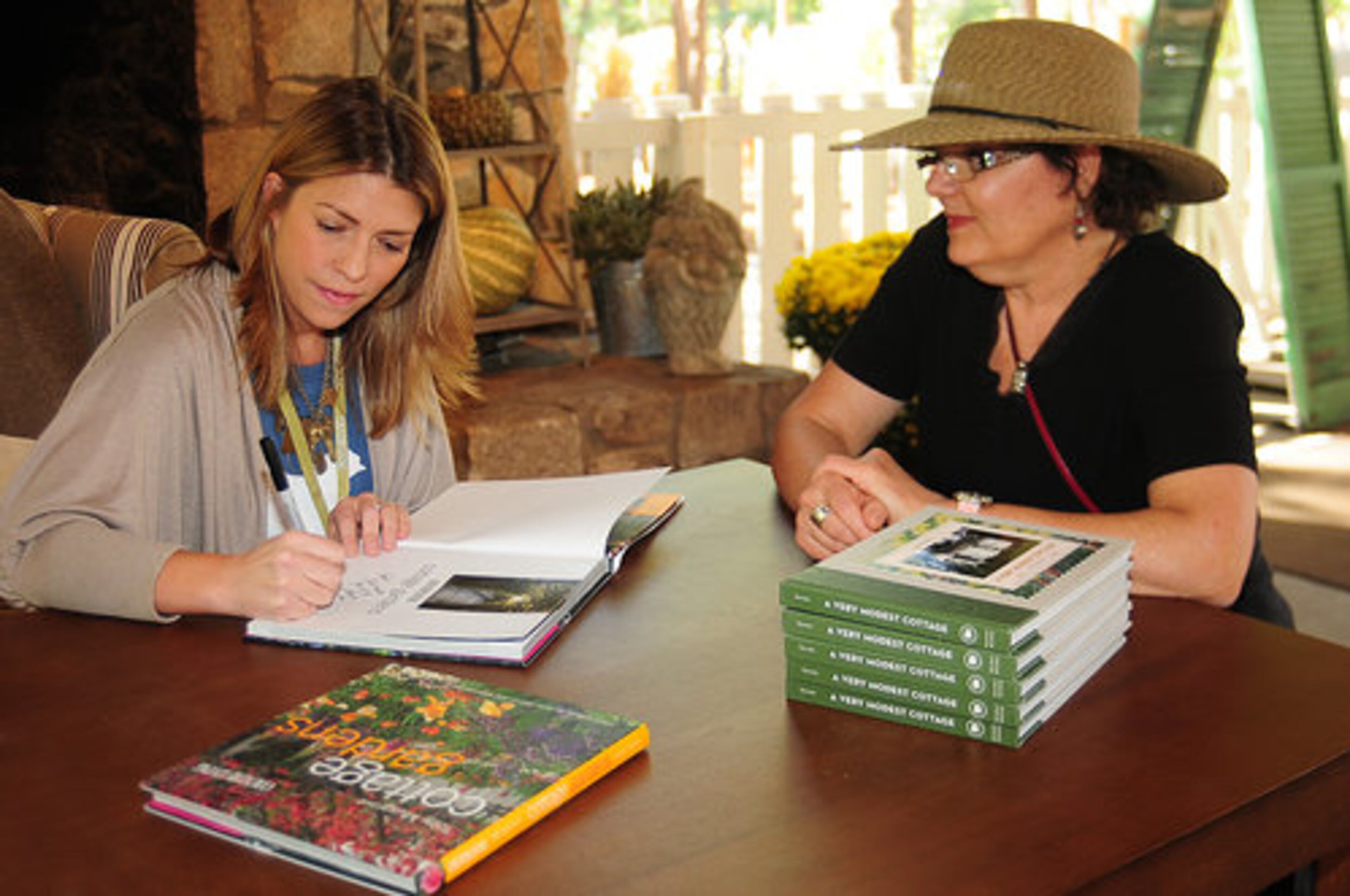Sarah Gray Miller, Country Living's editor-in-chief, signs a copy of "Cottage Gardens" for Carla Lenkey of Keokuk, Iowa, the winner of Country Living Fair sweepstakes.