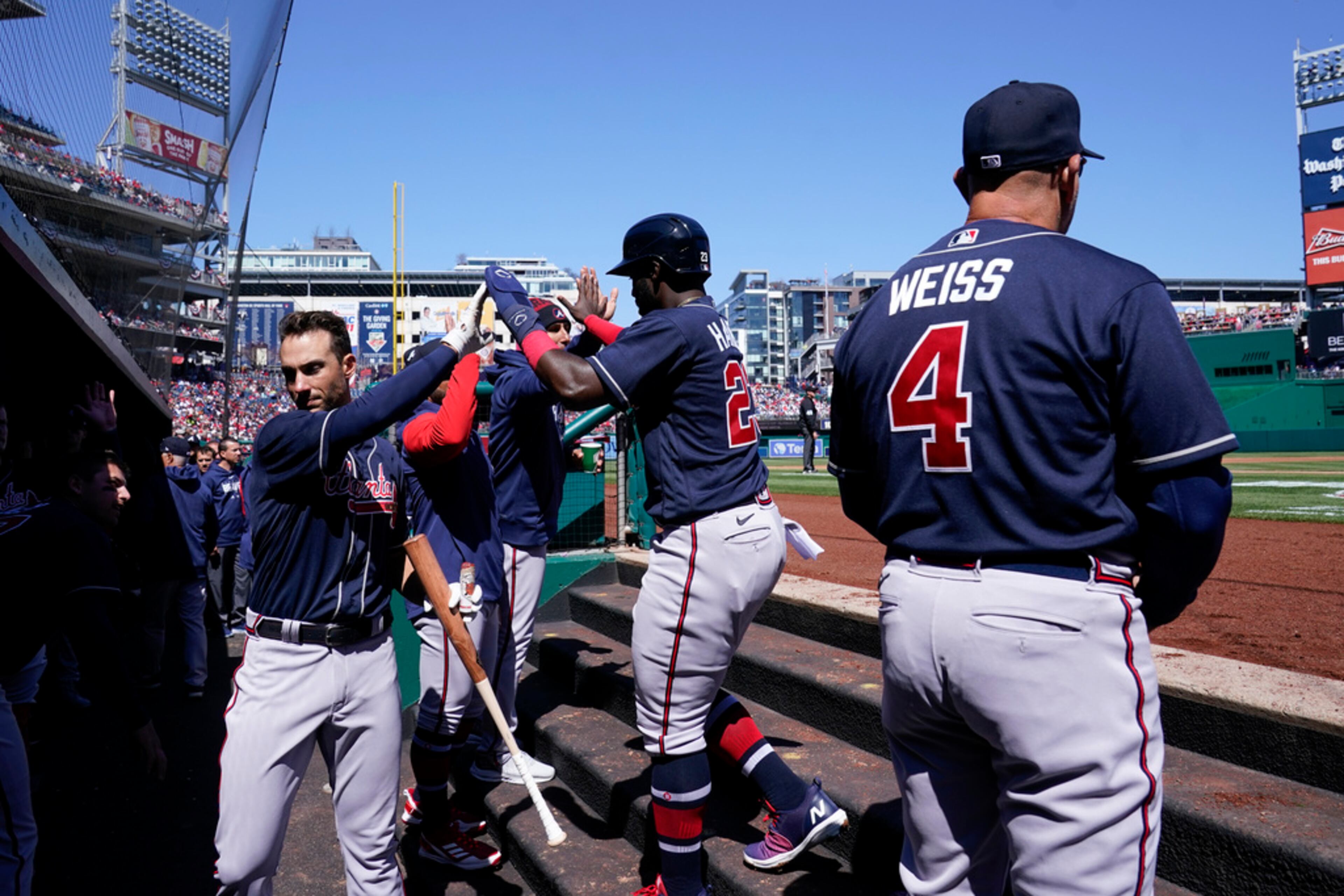 Atlanta Braves' Michael Harris II, center, high-fives teammates in the dugout after scoring on Orlando Arcia's single during the second inning of an opening day baseball game against the Washington Nationals at Nationals Park, Thursday, March 30, 2023, in Washington. (AP Photo/Alex Brandon)