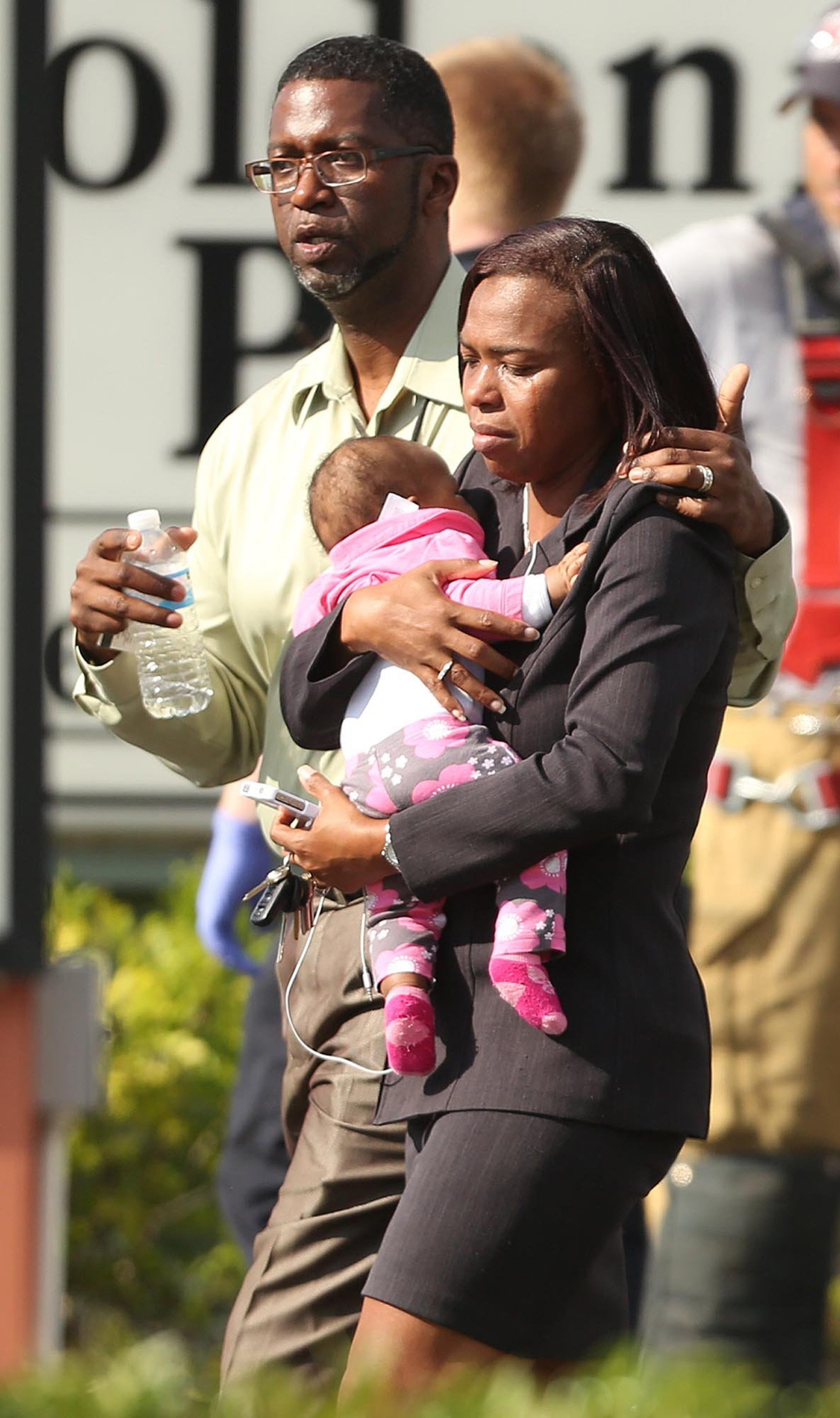 Children are escorted by their parents from the KinderCare Learning Center in Winter Park, Fla., after several children were injured when a car crashed into the facility Wednesday, April 9, 2014. (Stephen M. Dowell, Orlando Sentinel/MCT)