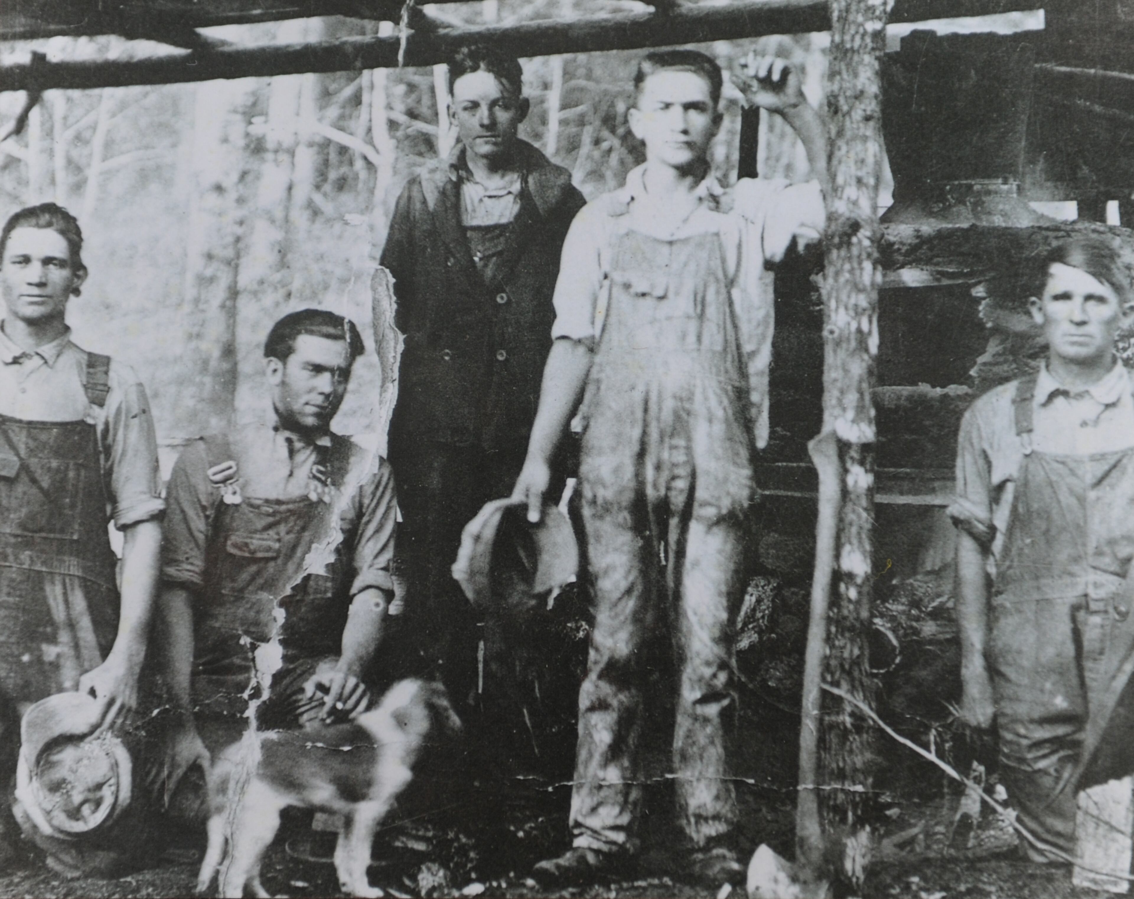 This photo is a copy from the original: Men identified only as Fricks, Rufus Mincey, Wehunt, Chester and Lingerfelt in front of a still in Dawson County in the 1940s.
