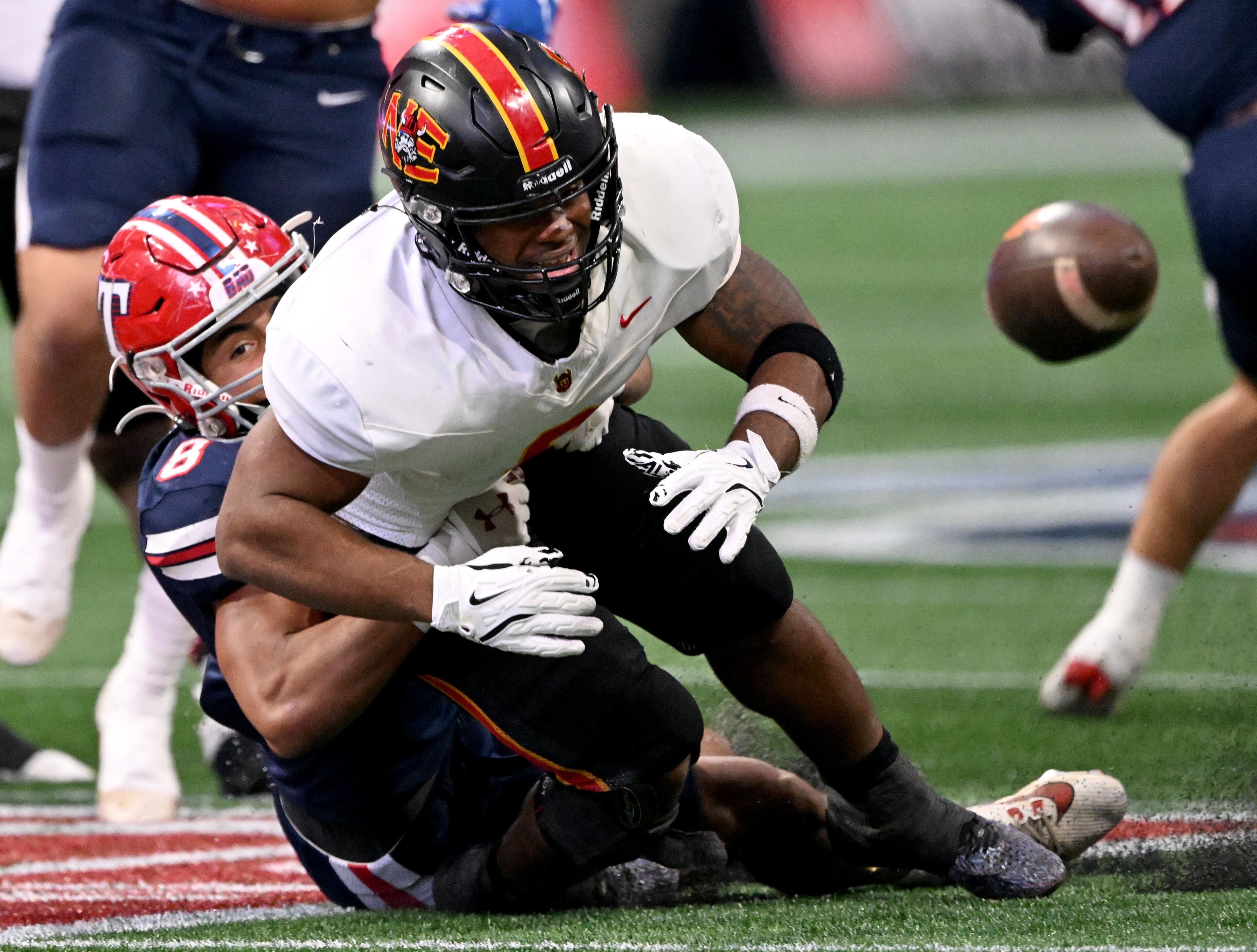 Northeast's running back Nick Woodford (6) fumble the ball as he gets tackled from behind by Toombs County's linebacker Hayden Roy (8) during the first half in GHSA Class A-Division State Championship game at Mercedes-Benz Stadium, Tuesday, December 17, 2024, in Atlanta. (Hyosub Shin / AJC)