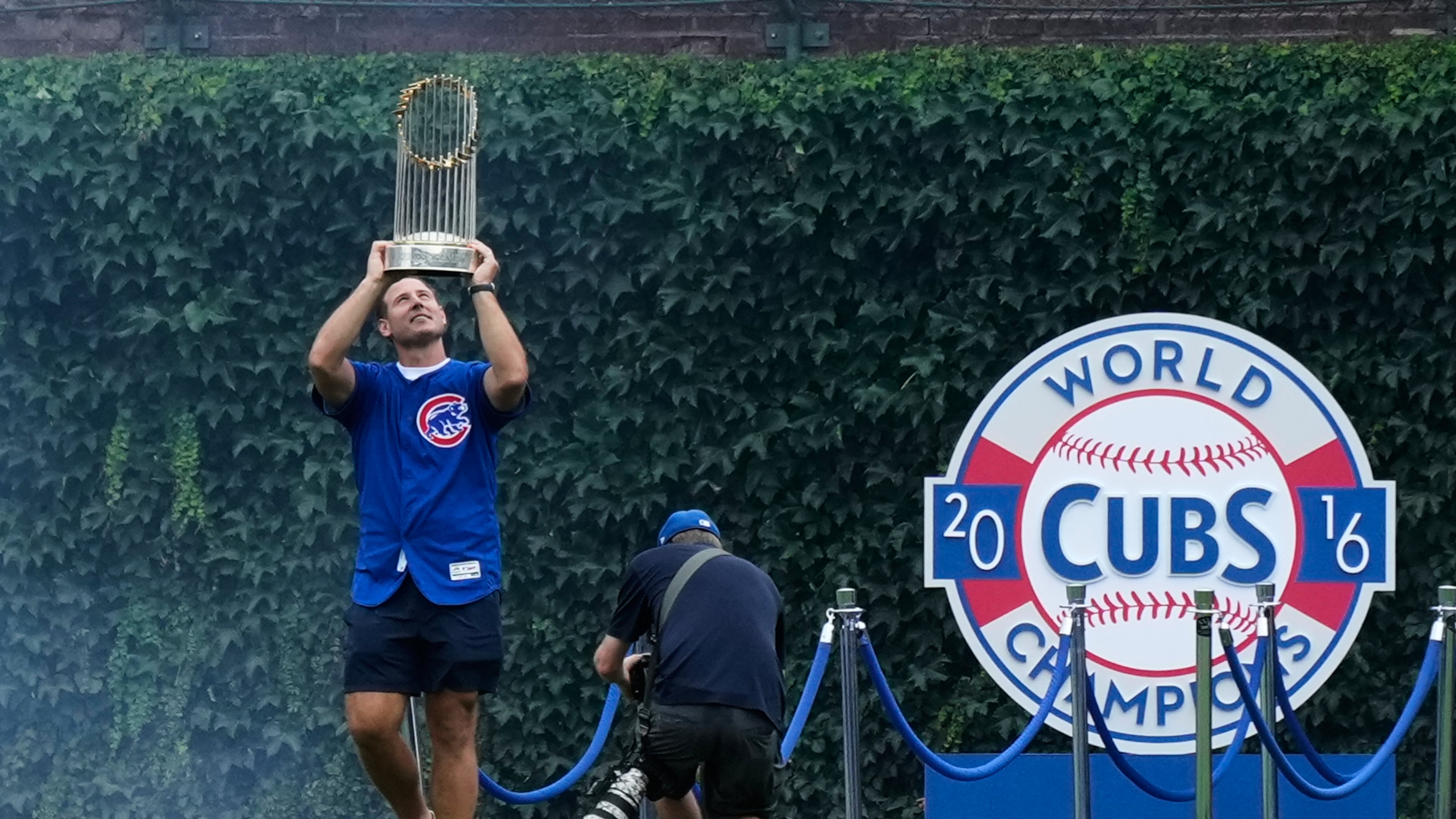 Former Chicago Cubs first baseman Anthony Rizzo holds up the 2016 World Series Championship trophy as his walks on the field before a baseball game between the Minnesota Twins and the Chicago Cubs in Chicago, Saturday, July 18, 2026. (AP Photo/Nam Y. Huh)