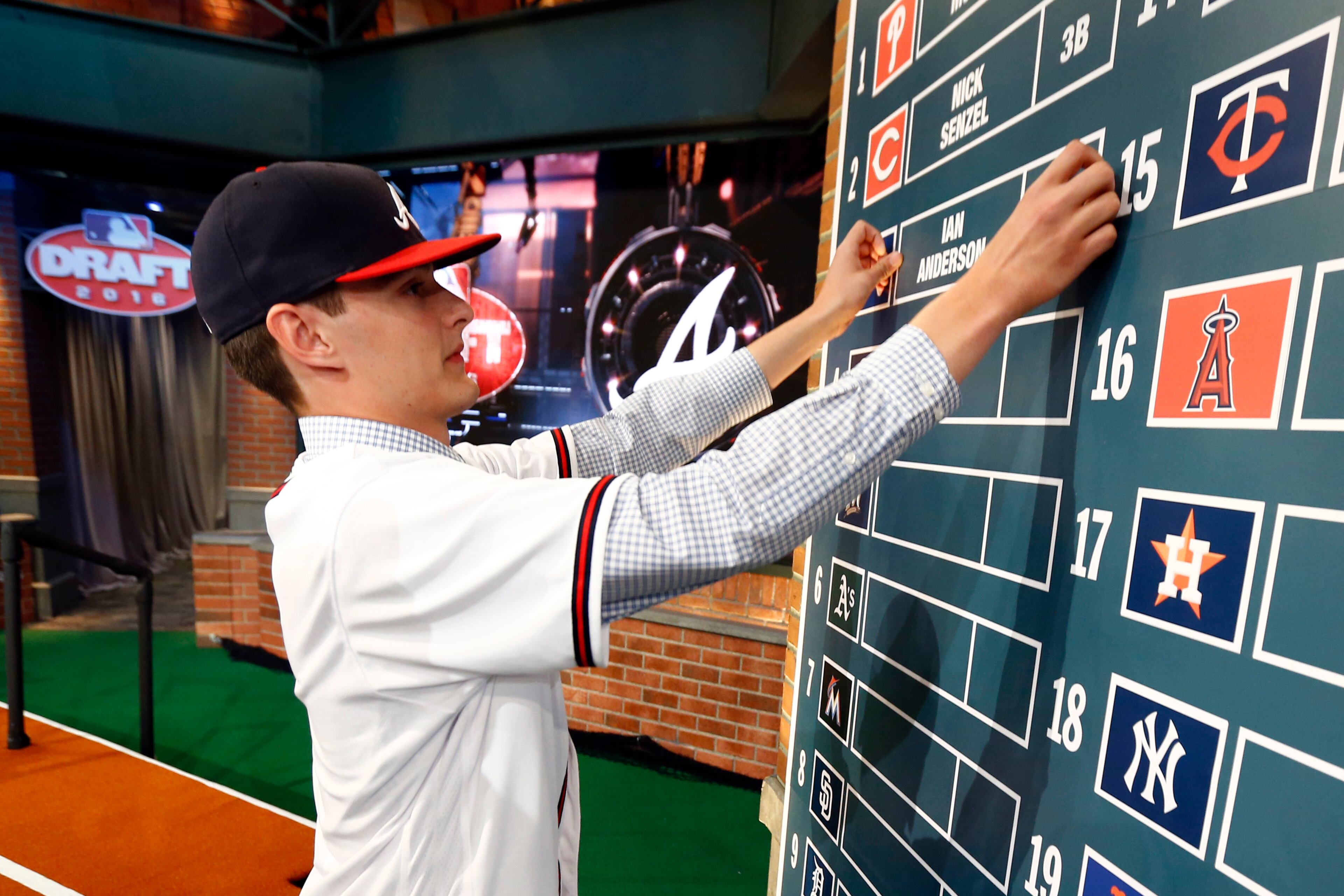 Ian Anderson, a pitcher from Shenendehowa High School in Clifton Park, N.Y., puts his name on the board after being drafted No. 3 by the Atlanta Braves in the first round of the baseball draft, Thursday, June 9, 2016, in Secaucus, N.J. (AP Photo/Julio Cortez)