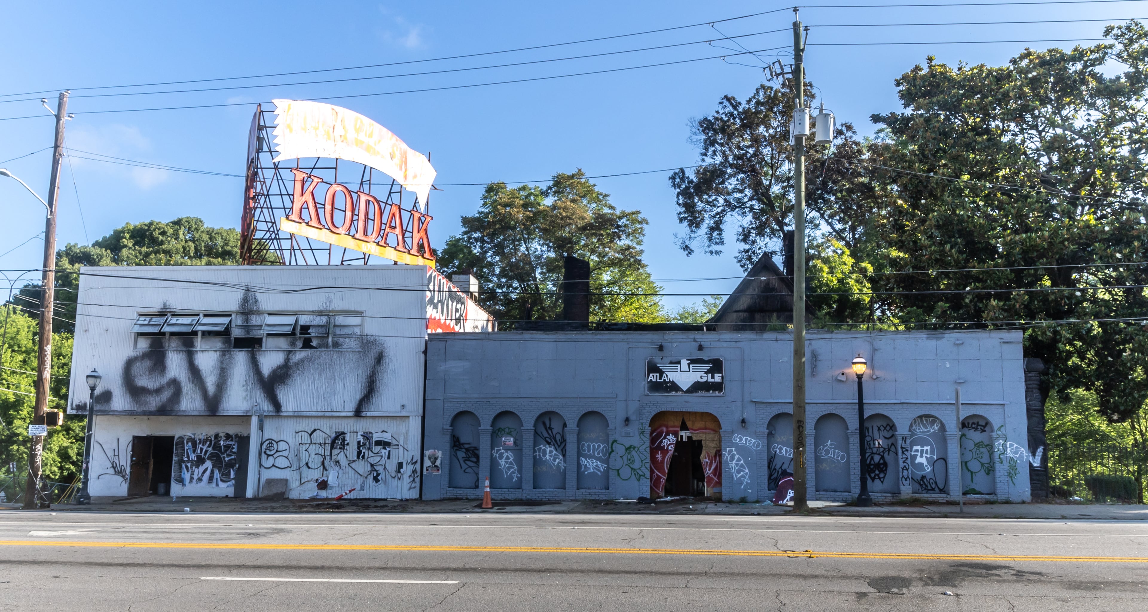 Officials and curious onlookers came to the scene of two historic buildings in northeast Atlanta on Friday, June 7, 2024 after they went up in flames Thursday evening. The blaze occurred at the old Atlanta Eagle gay bar and the Kodak building in the 300 block of Ponce de Leon Avenue in Midtown. (John Spink/AJC)