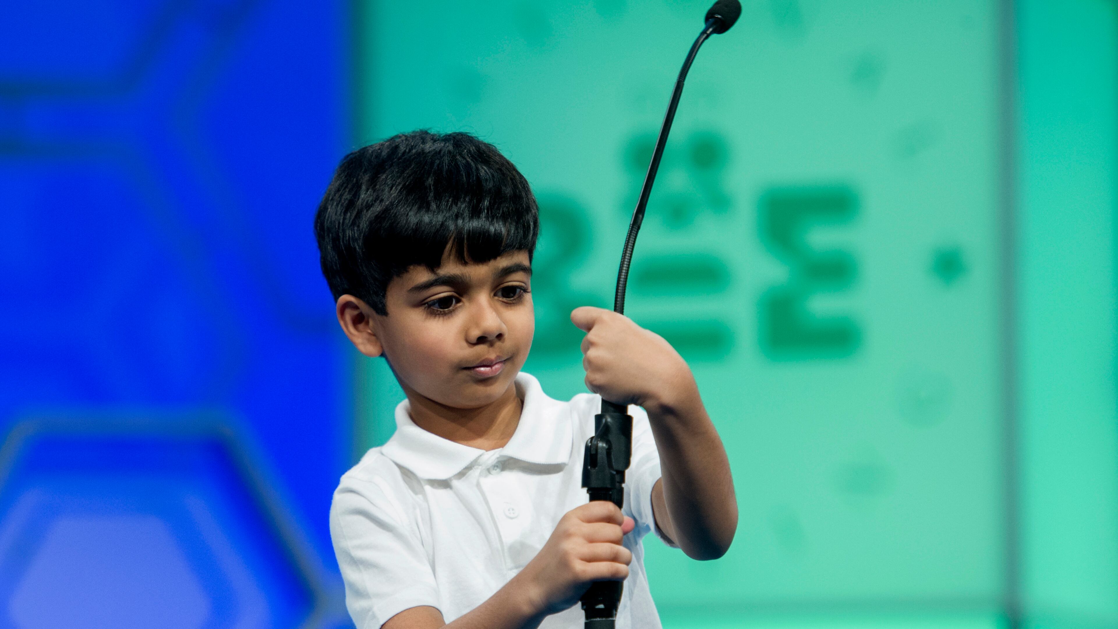 Akash Vukoti, 6, of San Angelo, Texas, tries to shorten the microphone before spelling his word during the preliminary round two of the Scripps National Spelling Bee in National Harbor, Md., Wednesday, May 25, 2016. Vukoti is the youngest speller in this year competition. (AP Photo/Cliff Owen)