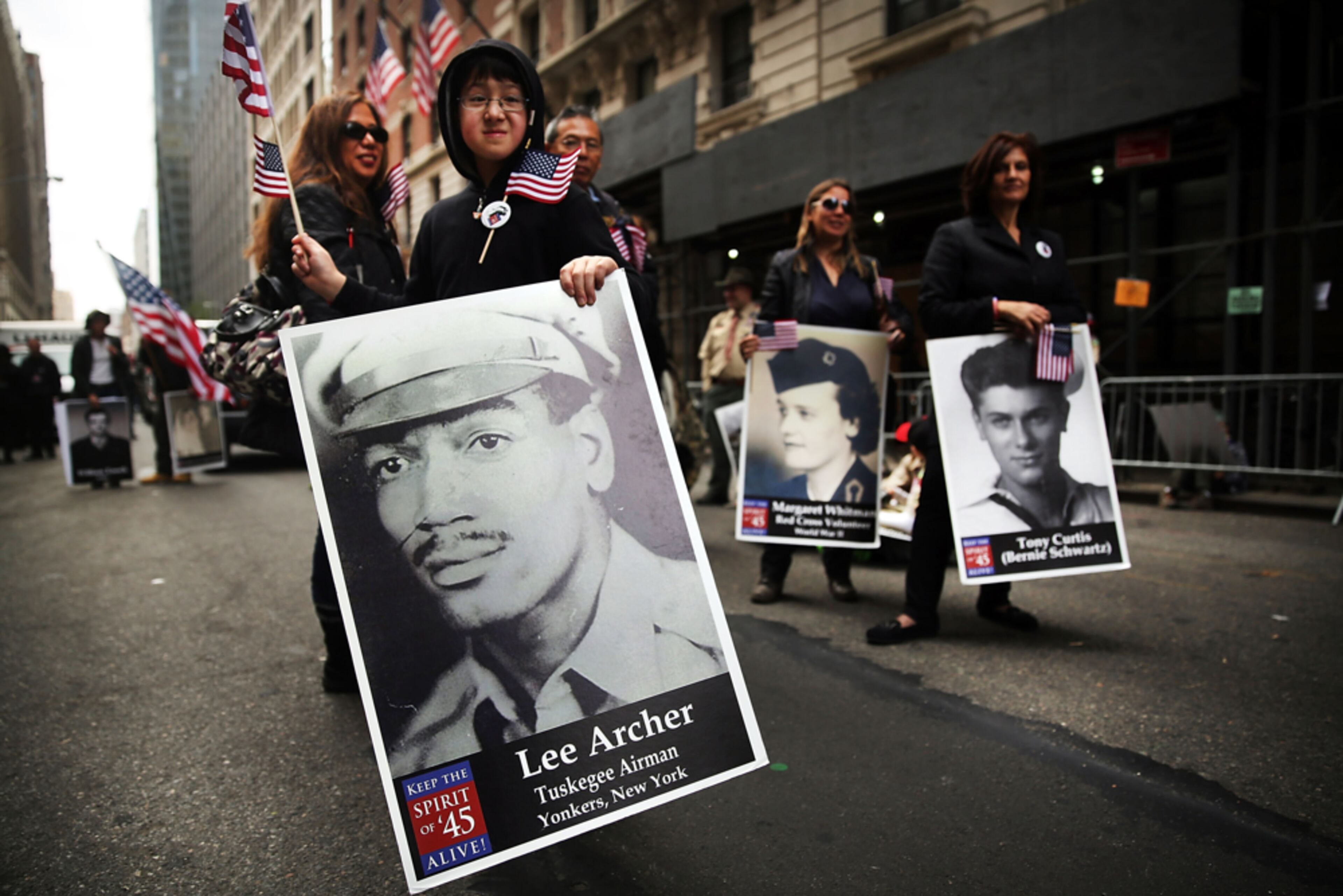 HISTORICAL REMINDERS--NEW YORK, NY - NOVEMBER 11: Members of a local boy scout troop hold poster sized photos of WWII veterans from their local community as they prepare to march in the annual Veteran's Day Parade along Fifth Avenue on November 11, 2014 in New York City. Often called the largest Veteran's Day Parade in the country, more than 600,000 people are expected to line the streets for the parade which celebrates the scarifies soldiers have made for the country. (Photo by Spencer Platt/Getty Images)