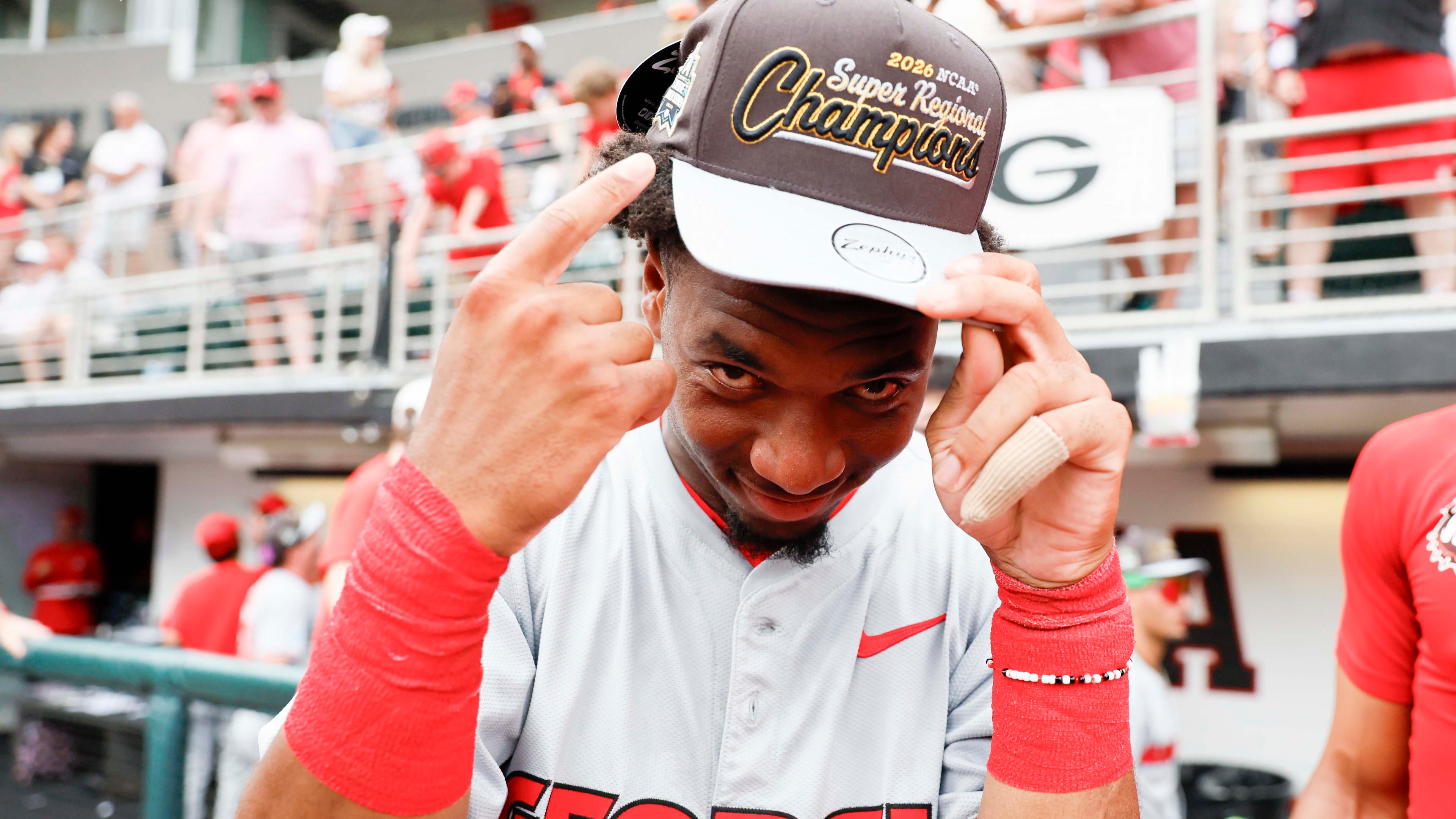 Georgia infielder Ryan Wynn points at his championship hat as he celebrates with his team after winning an NCAA super regional against Mississippi State at Foley Field on Sunday, June 7, 2026, in Athens. (Miguel Martinez/AJC)