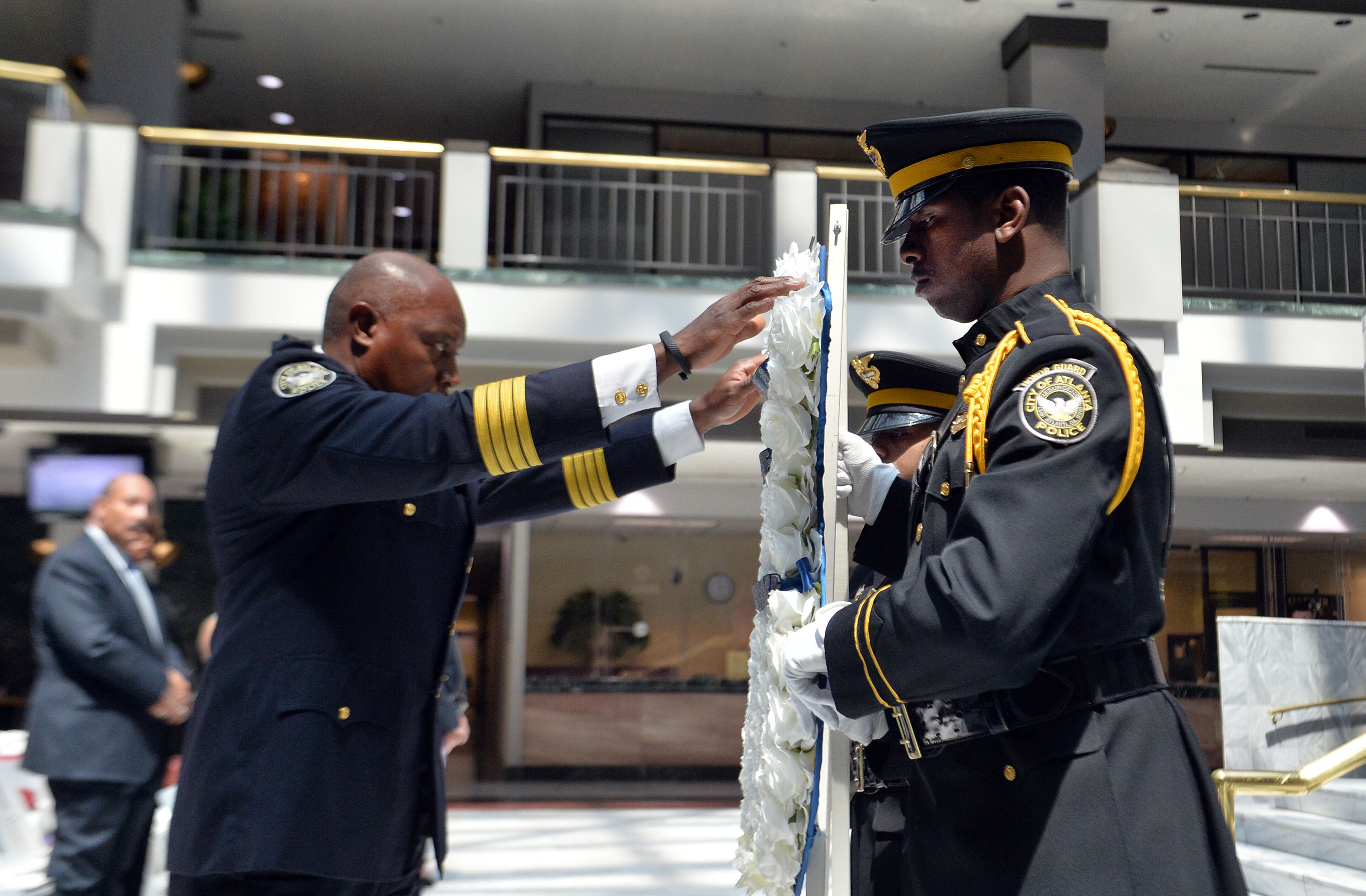 Police Chief George Turner, Officers Charles Phillips and Marquis Feagan present a wreath during the service. The Atlanta Police Department recognized 82 fallen officers during the 24th Annual Police Memorial Service at the Atlanta City Hall atrium, Tuesday, May 5, 2015. The Right Rev. Robert C. Wright of the Episcopal Diocese of Atlanta was the keynote speaker. Additional speakers included Atlanta Police Chief George N. Turner, Michael Geisler, Chief Operating Officer, City Council President Ceasar C. Mitchell and Council member C.T. Martin, Public Safety Chair. KENT D. JOHNSON /KDJOHNSON@AJC.COM
