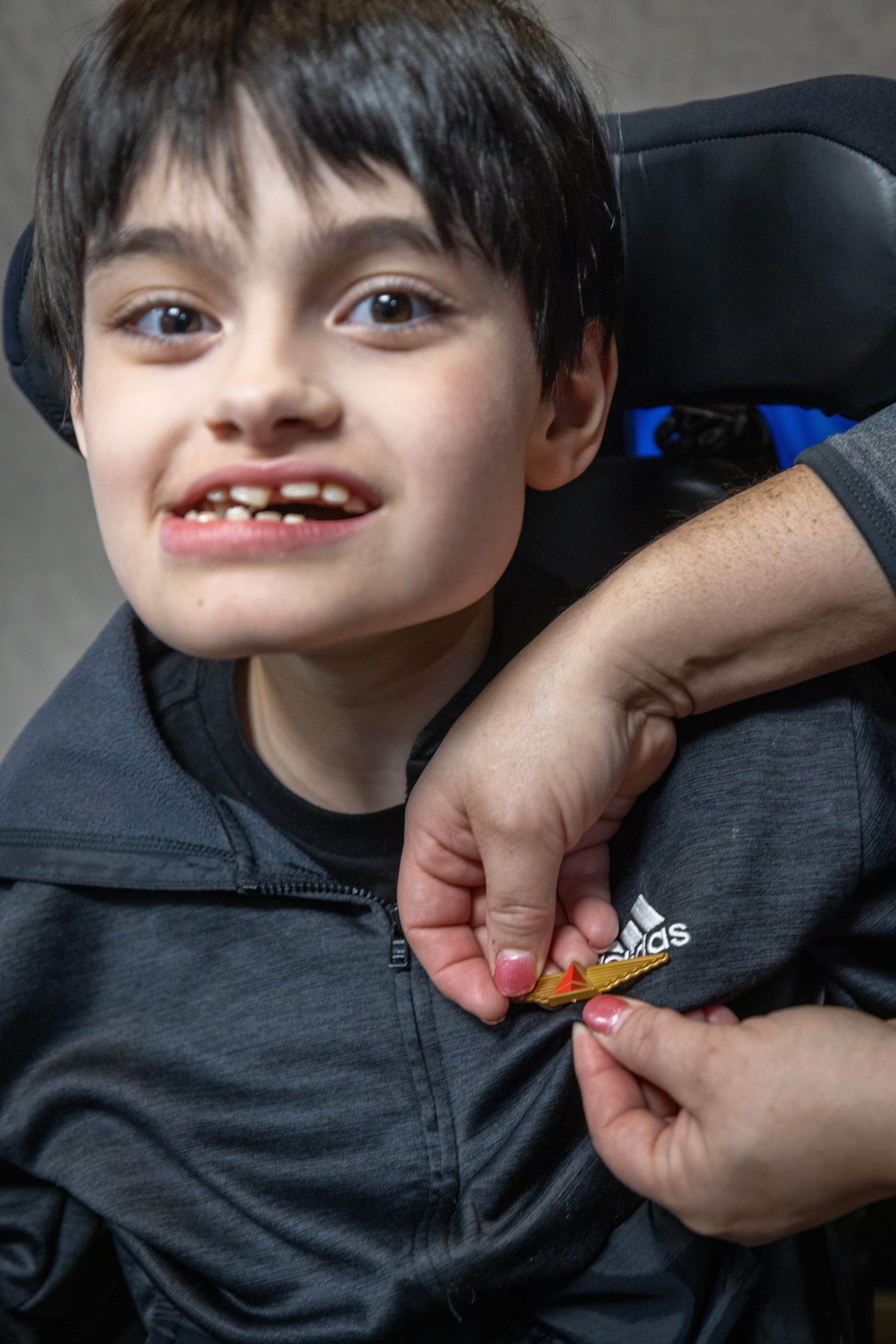 Jennifer Mauney pins gold wings on to her son Jackson, 11, during a Wings For All event at the Hartsfield-Jackson Atlanta International Airport Tuesday, April 11, 2023. (Steve Schaefer/steve.schaefer@ajc.com)