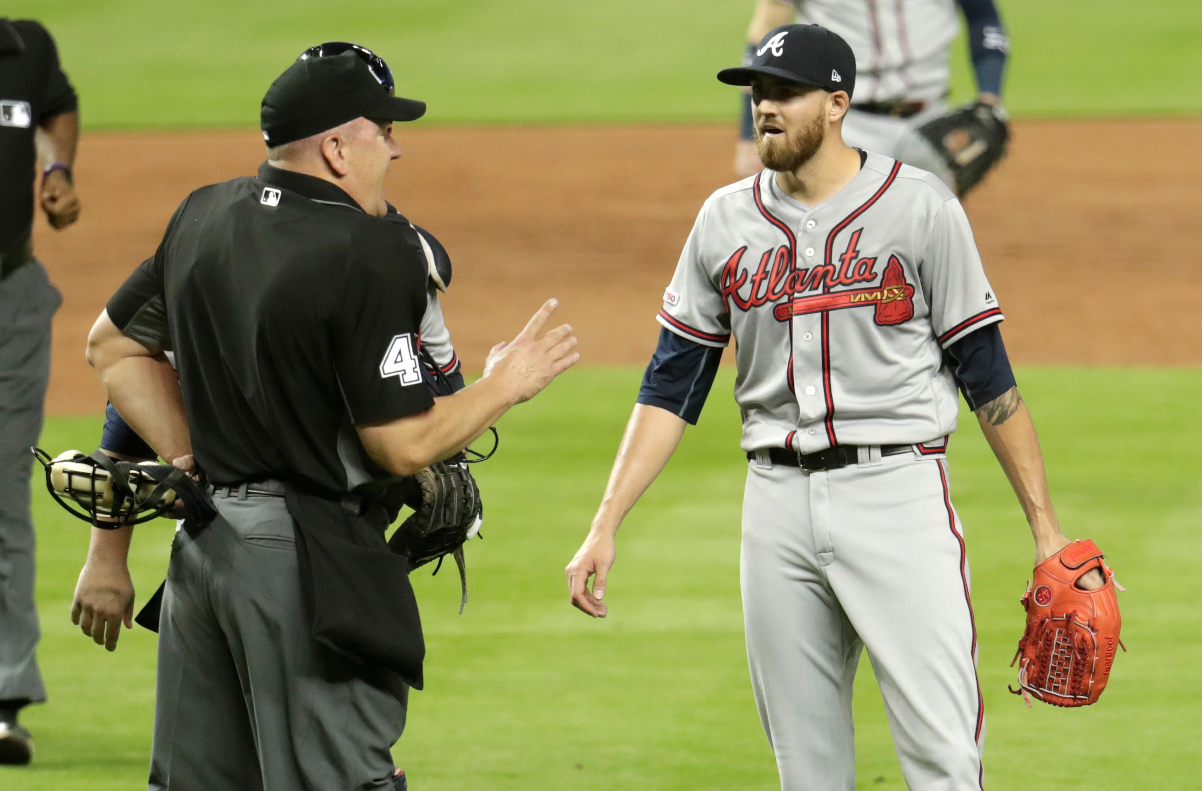 Home plate umpire Jeff Nelson, left, talks with Atlanta Braves starting pitcher Kevin Gausman after Gausman was ejected for throwing at Miami Marlins' Jose Urena during the second inning of a baseball game Friday, May 3, 2019, in Miami. (AP Photo/Lynne Sladky)