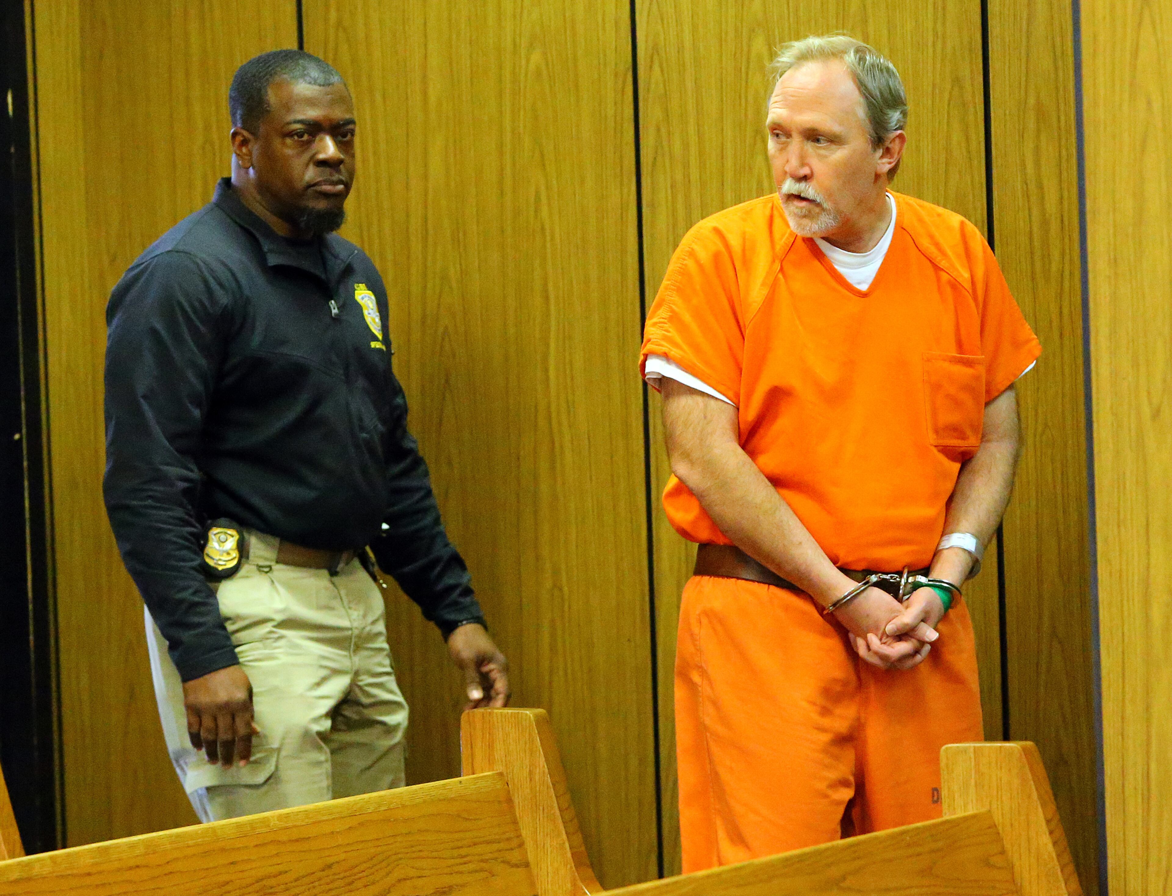 John McGill, principal of Mt. Carmel Elementary School in Douglas County, is brought into the courtroom for his first appearance hearing at DeKalb County Magistrate Court for a felony offense of electronic pornography and child exploitation on Tuesday, March 4, 2014, in Decatur.