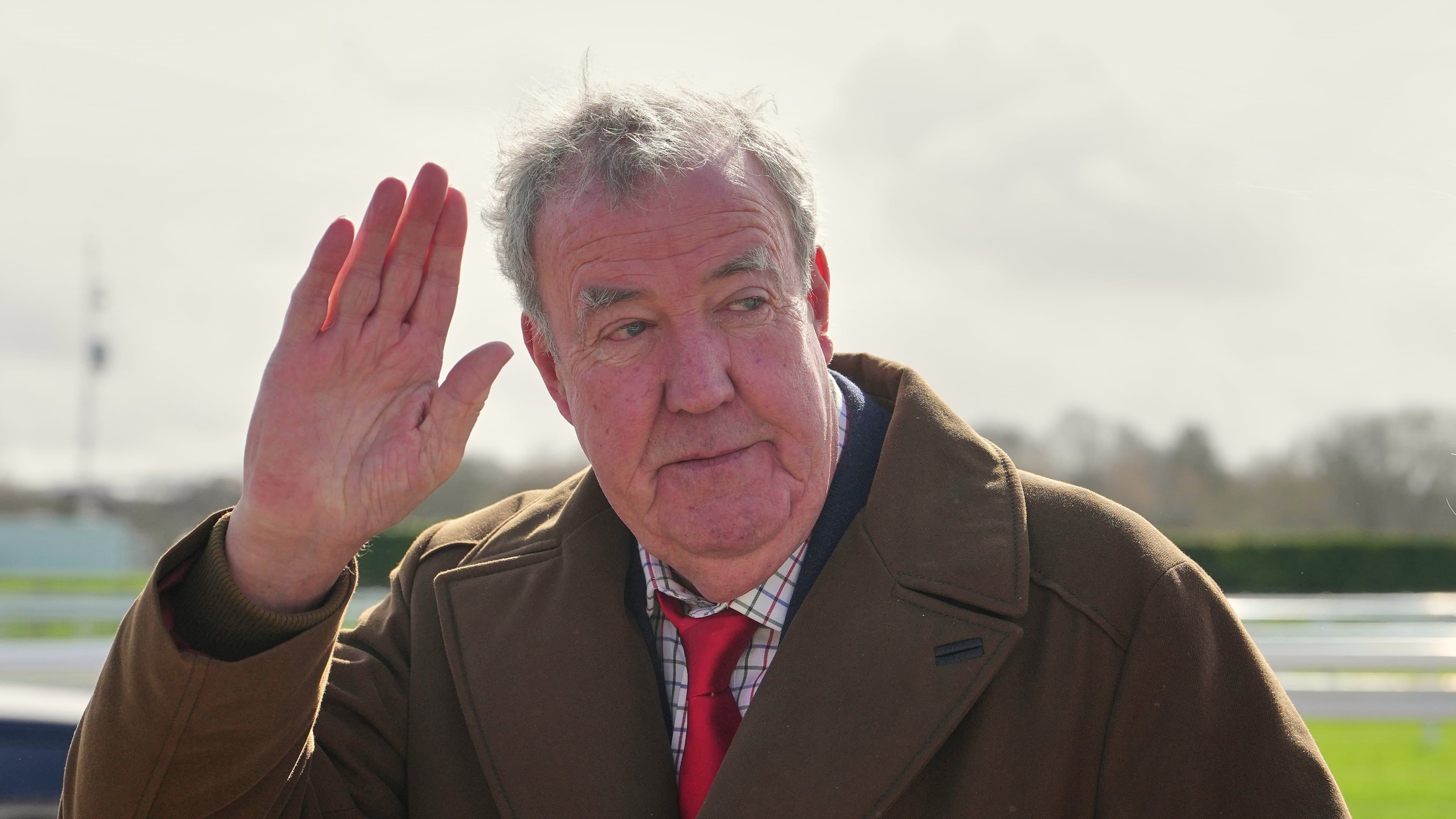 FILE - TV presenter Jeremy Clarkson waves to the media as he arrives on day four of the 2026 Cheltenham Festival in Cheltenham, England, on March 13, 2026. (AP Photo/Dave Shopland, File)