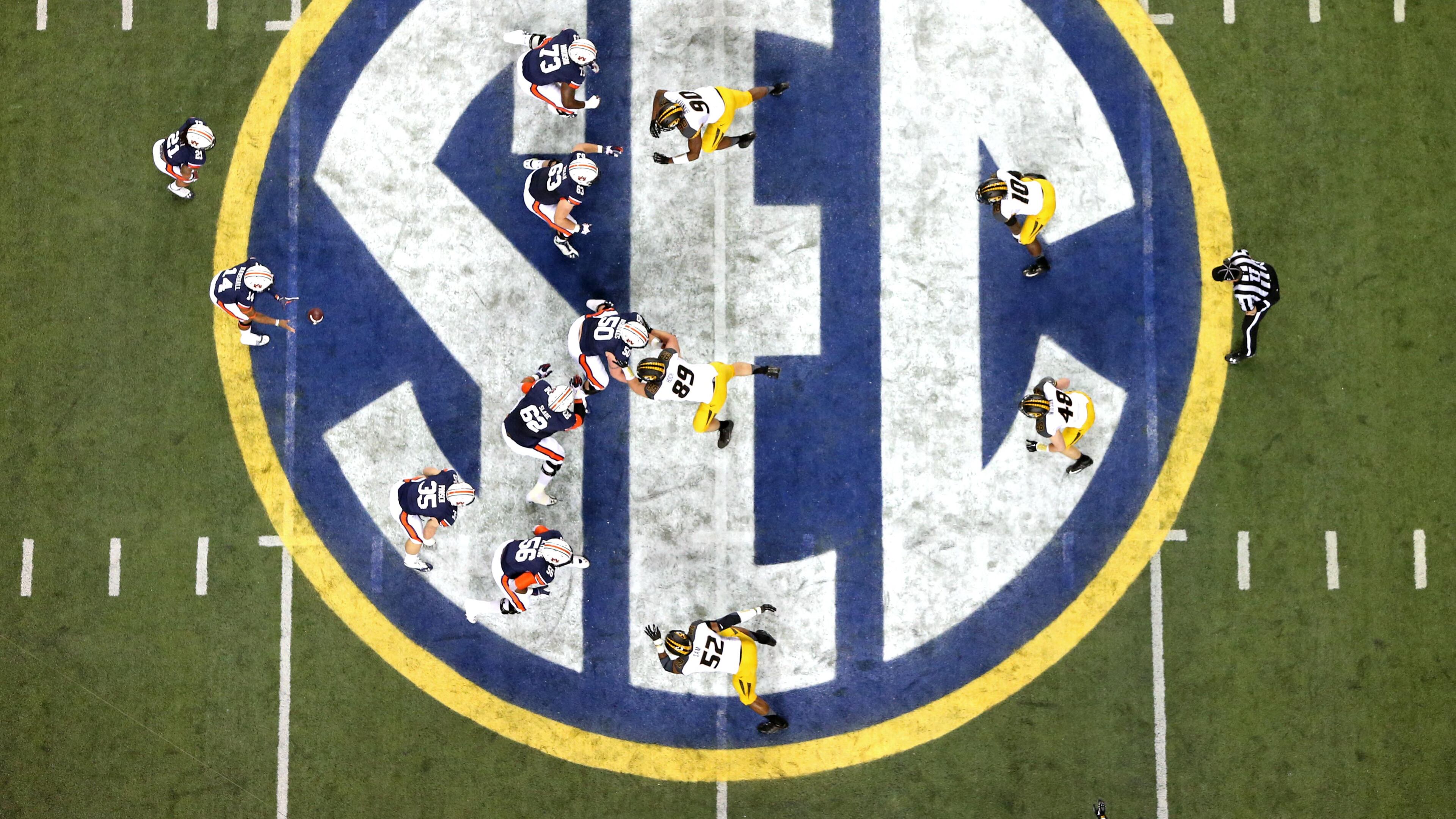 Auburn quarterback Nick Marshall (14), left, takes the snap from Auburn center Reese Dismukes (50) as the Auburn offense operates against Missouri on the SEC logo during the first half of Auburn's 59-42 win over Missouri in the SEC Championship at the Georgia Dome Saturday afternoon in Atlanta, Ga., December 7, 2013. JASON GETZ / JGETZ@AJC.COM