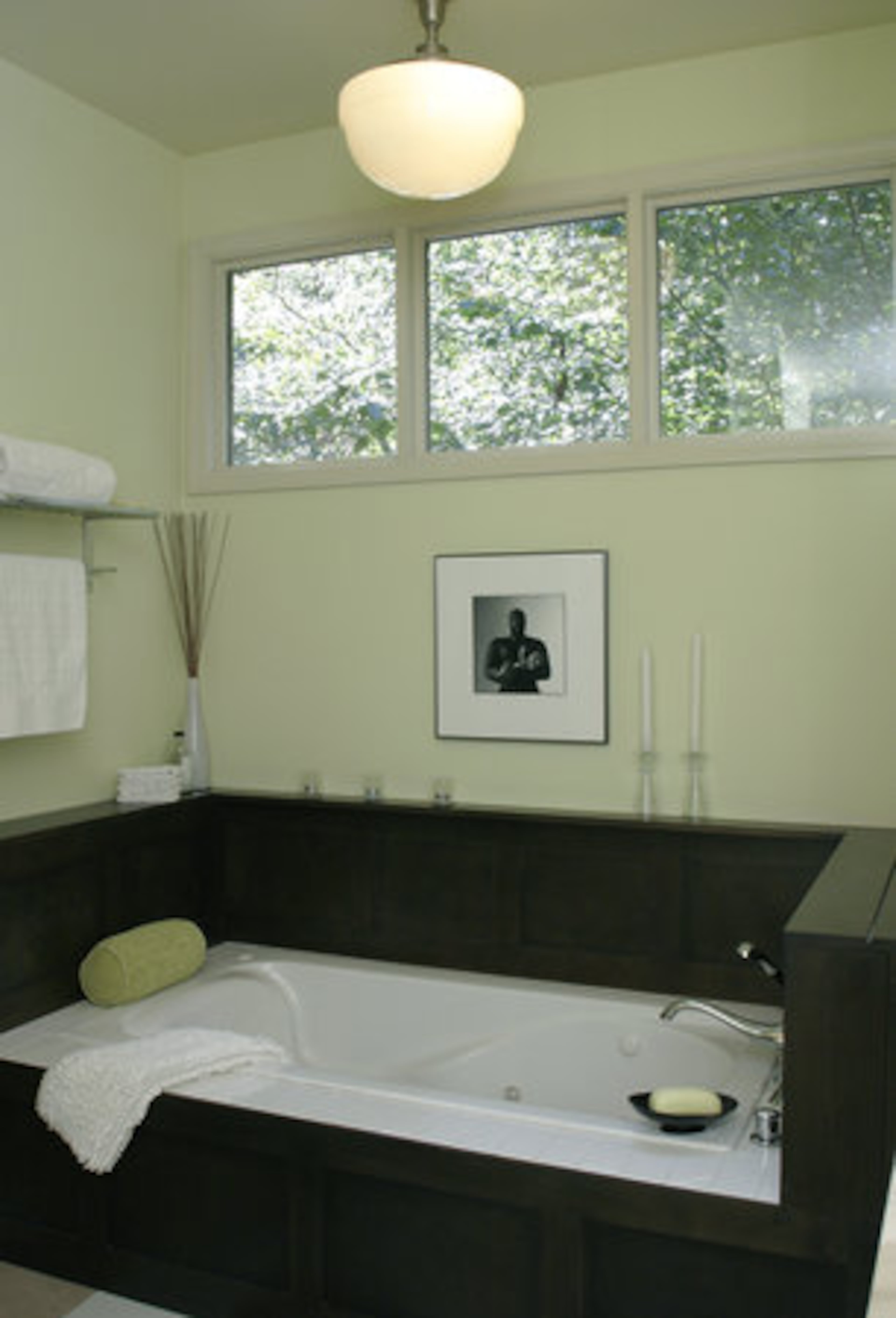 The spa tub is surrounded by in dark wood, and the light is a schoolhouse-style.