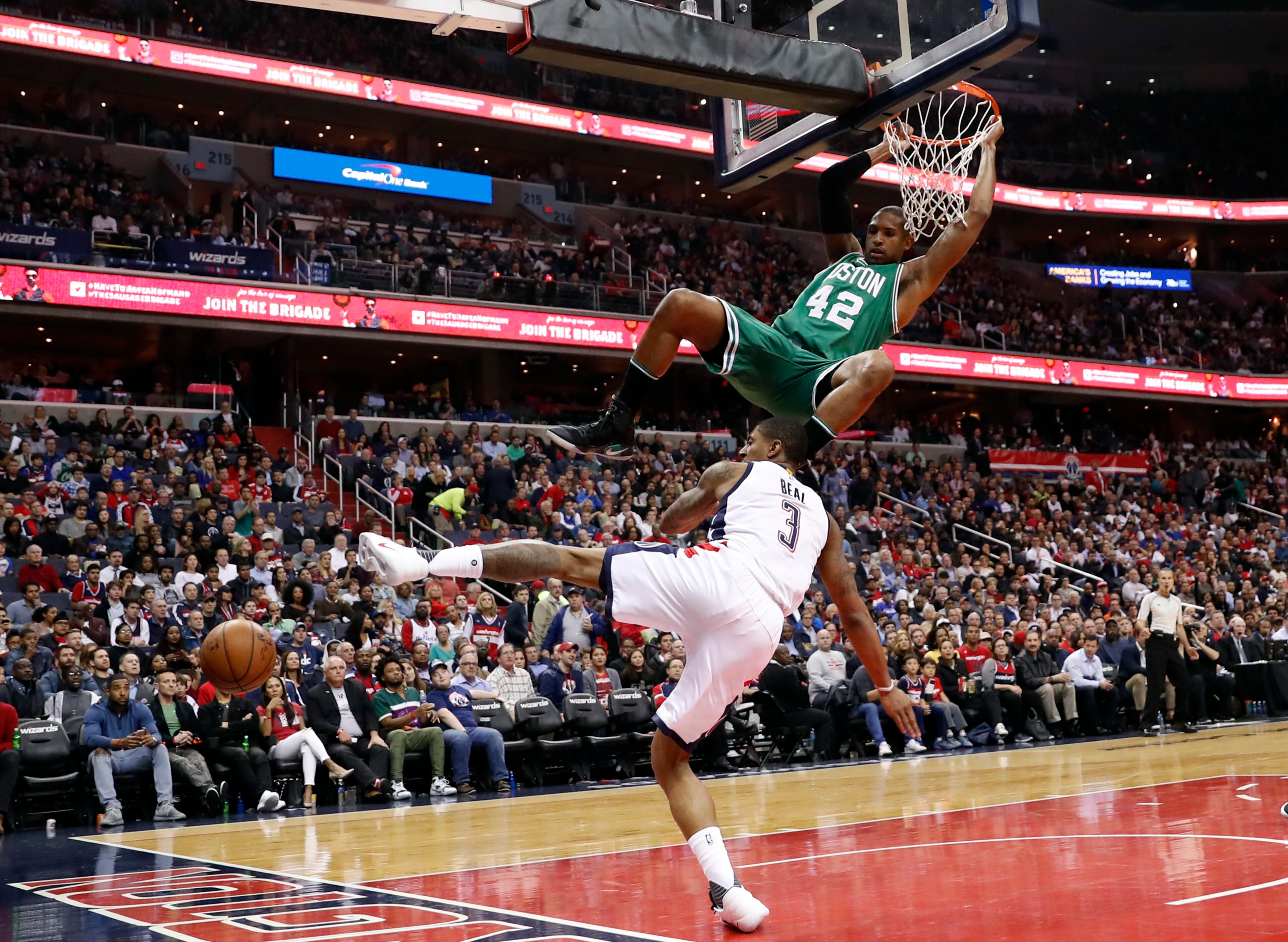 Boston Celtics center Al Horford hangs from the rim after dunking the ball over Washington Wizards guard Bradley Beal (3) during the second half of Game 6 of an NBA basketball second-round playoff series, Friday, May 12, 2017, in Washington. The Wizards won 92-91. (AP Photo/Alex Brandon)