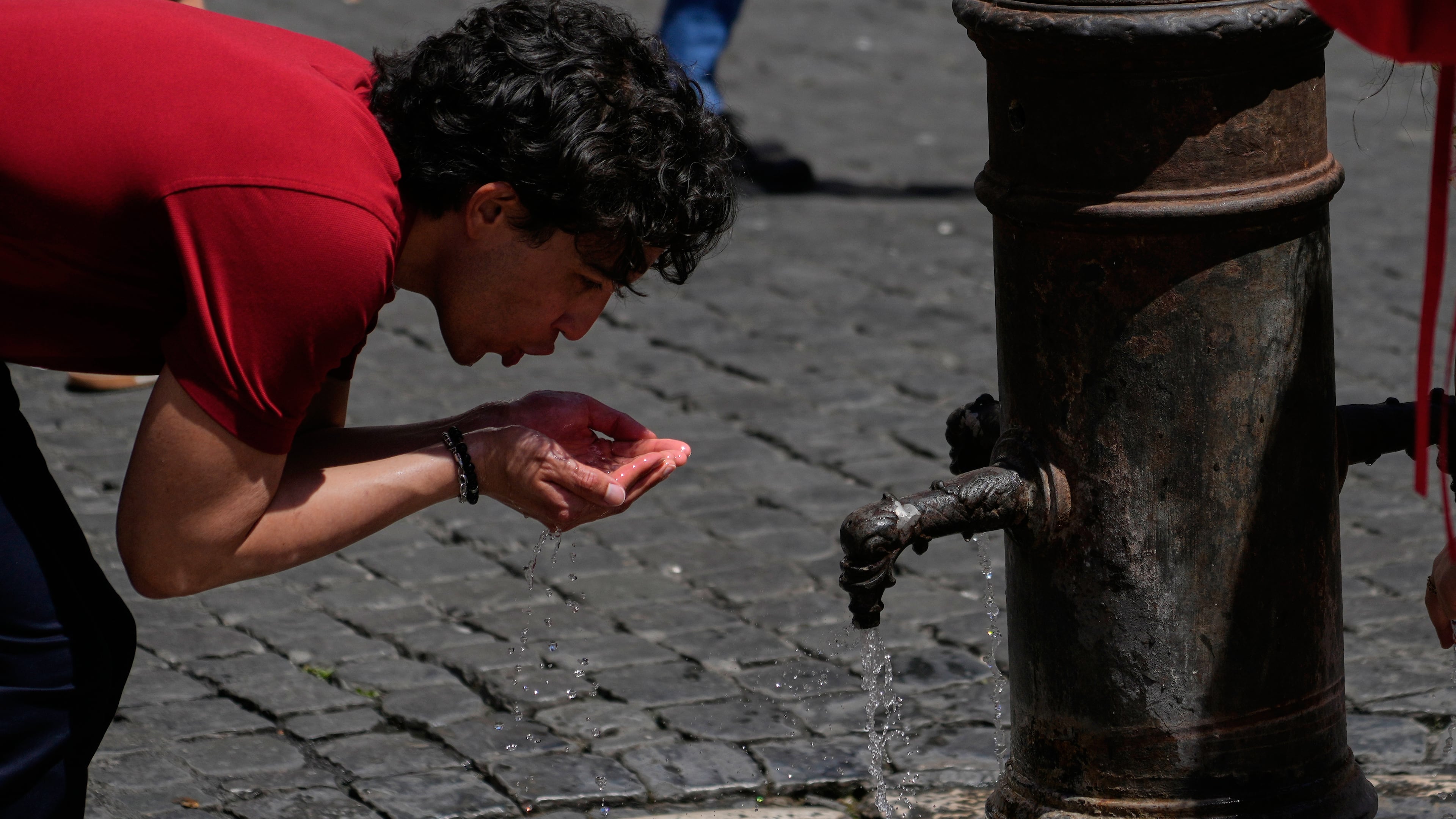 A man drinks water at a fountain in downtown Rome as temperatures are expected to reach 32 degrees Celsius (89.6 Fahrenheit), Tuesday, May 26, 2026. (AP Photo/Gregorio Borgia)